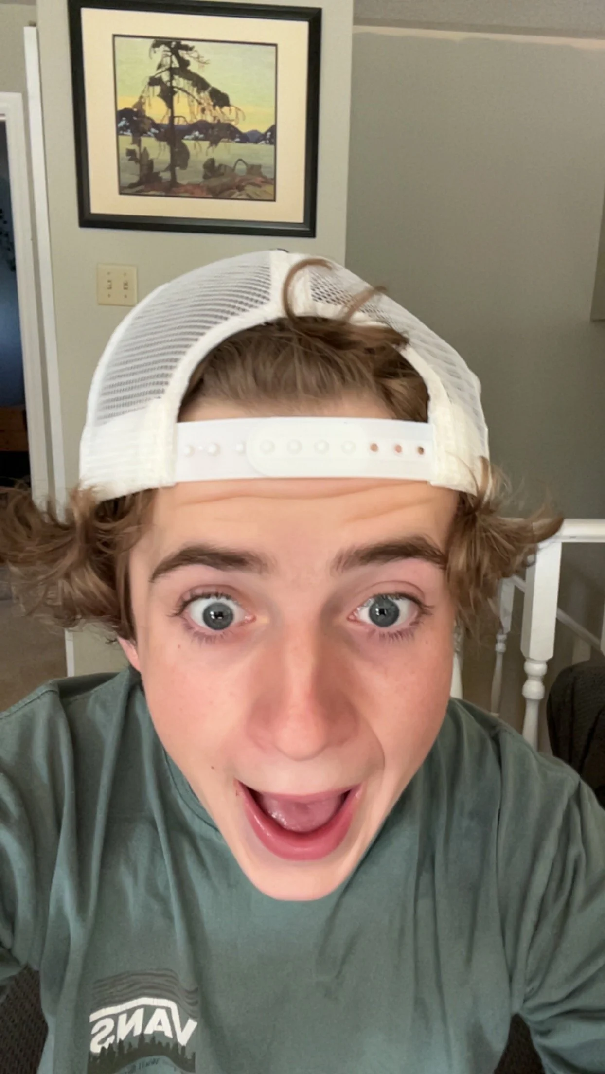 Lucas Crump, wearing a backward baseball cap, smiling with wide eyes.