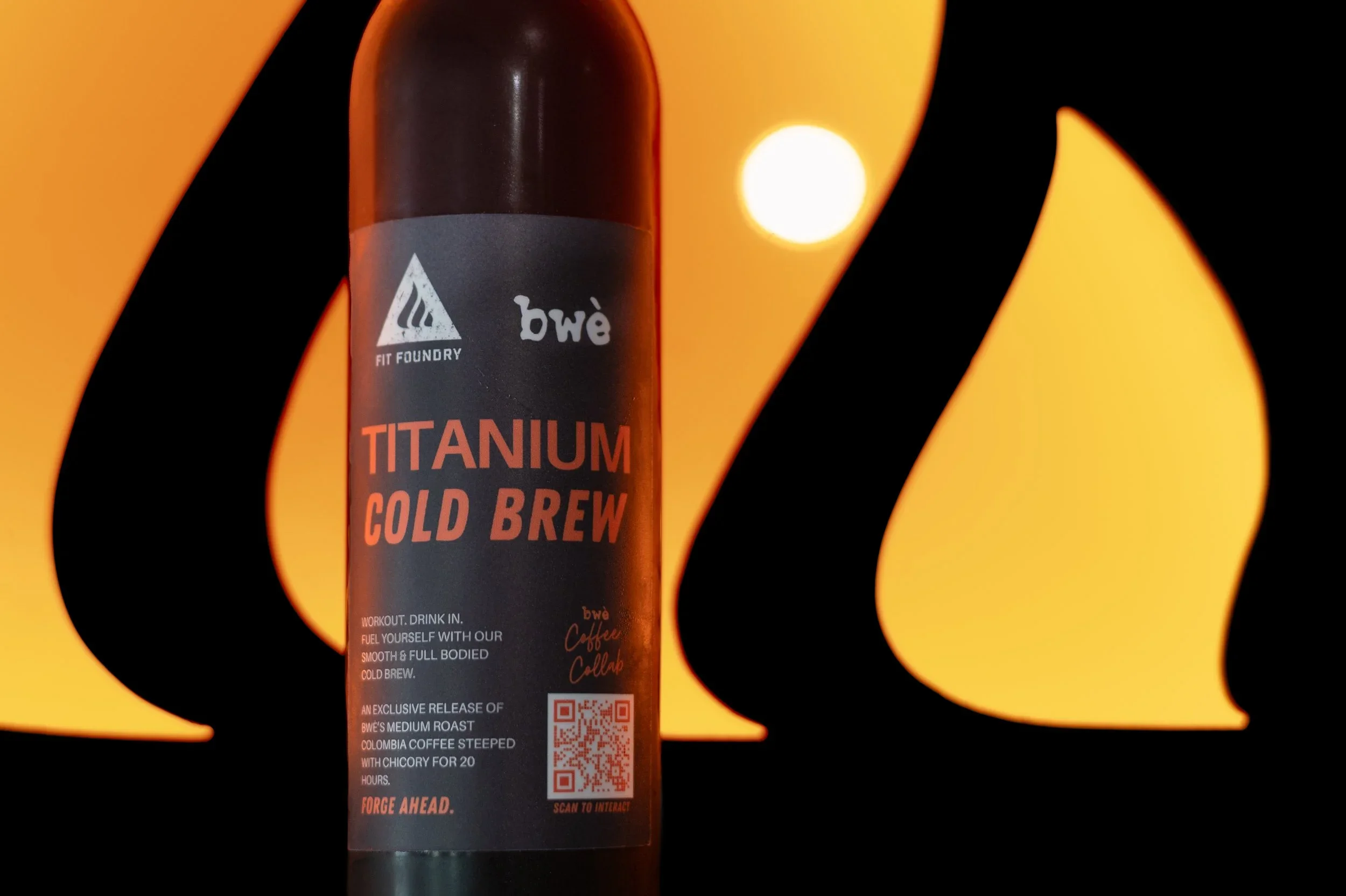 A bottle of Bwe Titanium Cold Brew coffee against a yellow and black abstract background with a circular light.