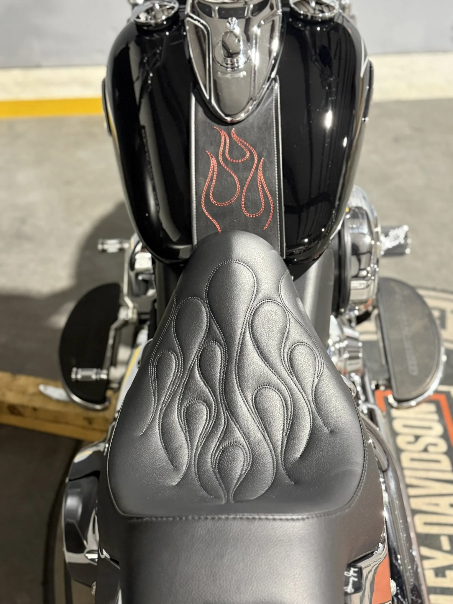 Top view of a black motorcycle with flame designs on the seat and fuel tank.