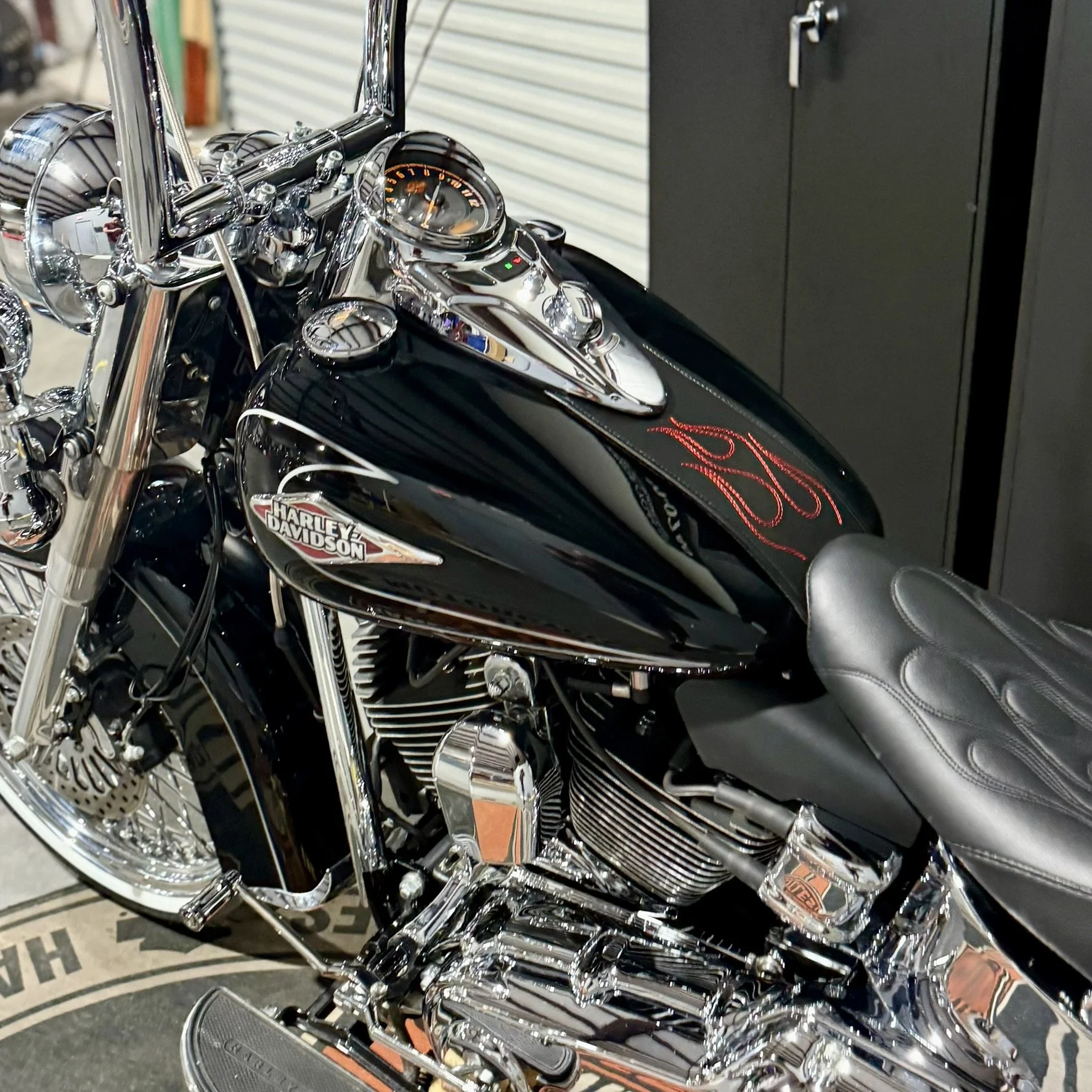 Close-up of a black Harley Davidson motorcycle with chrome details and a black leather seat.