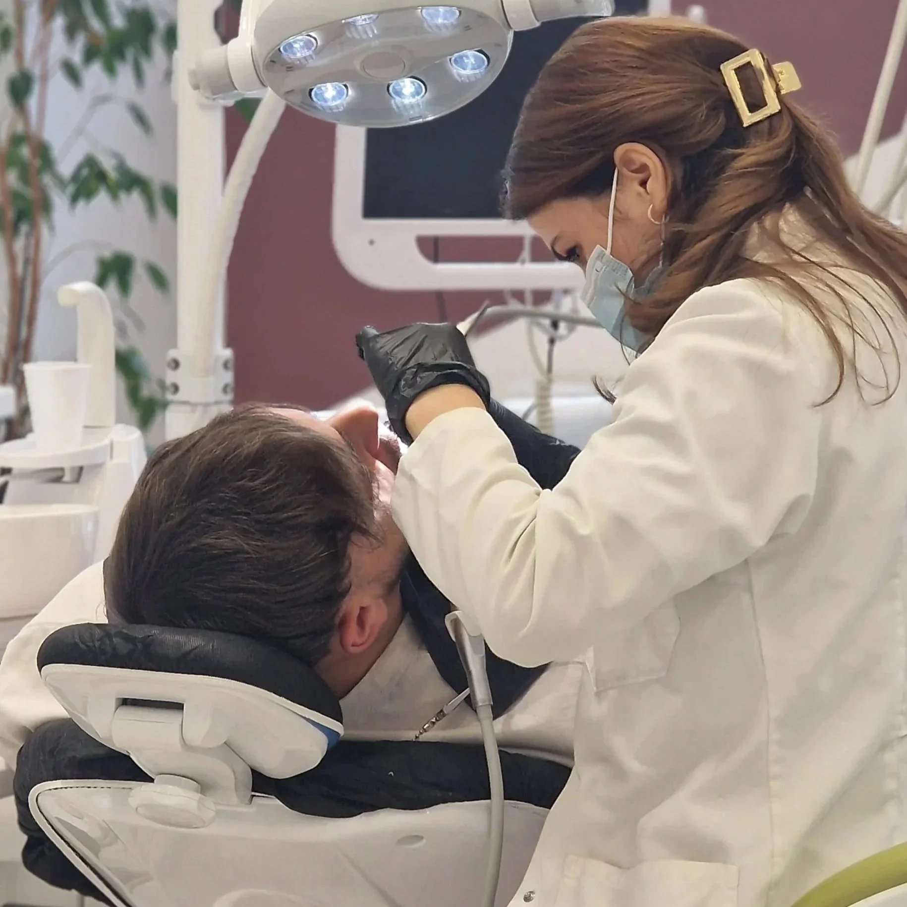 Dentist examining a patient's teeth at dental clinic.