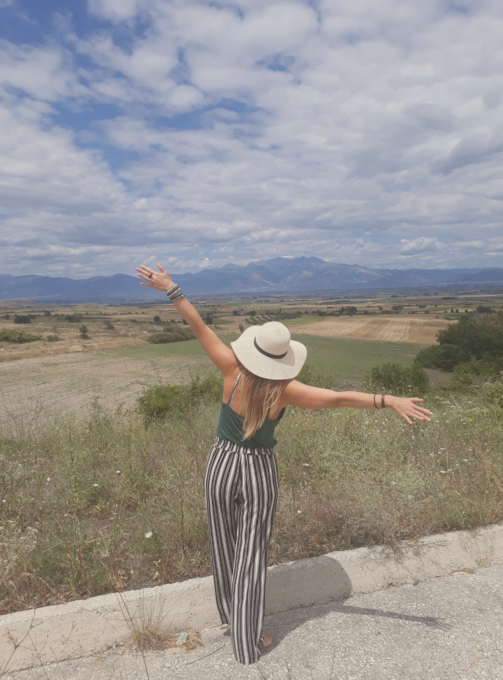 woman standing with arms open in nature