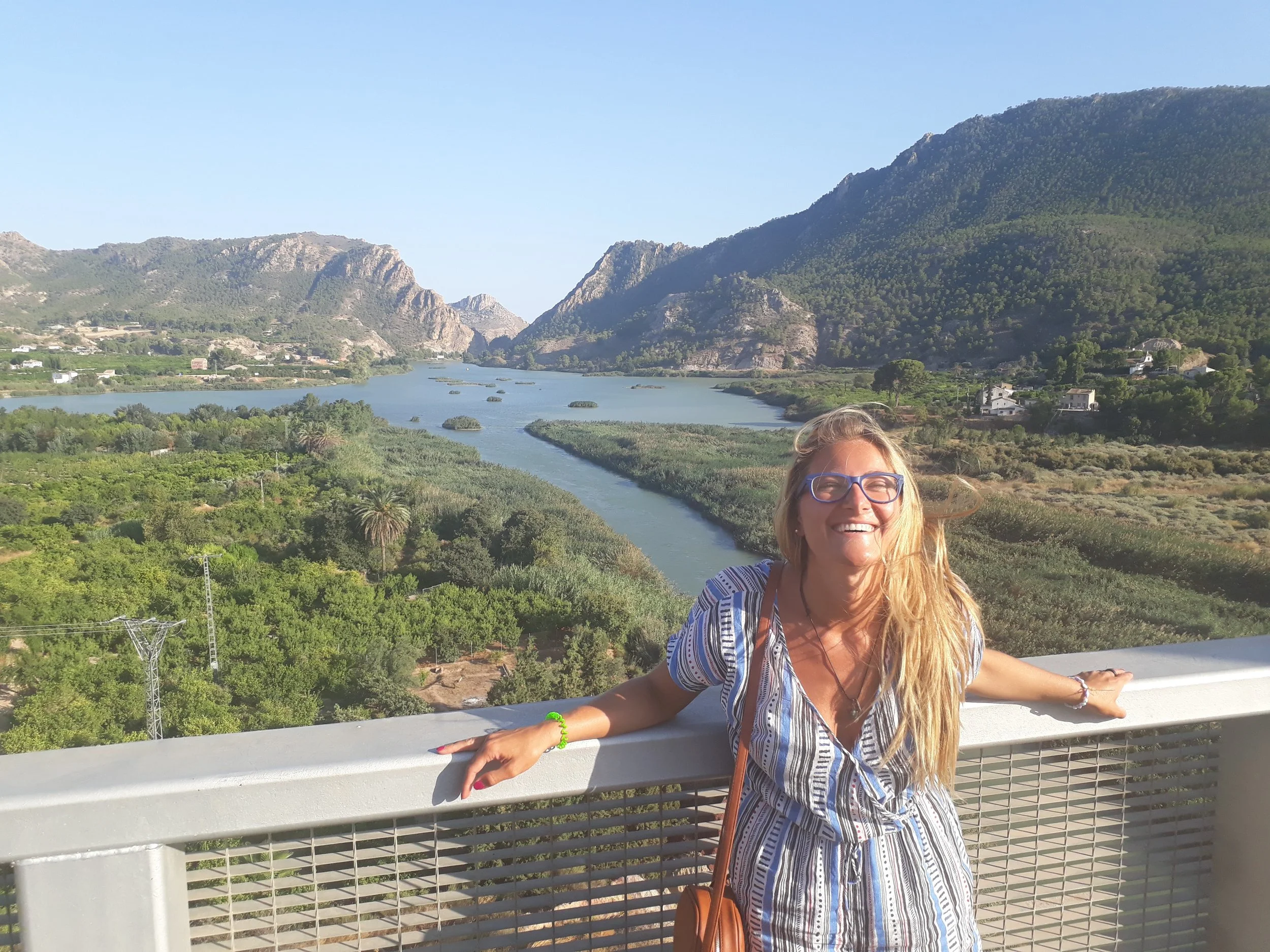 Martina's standing in nature smiling