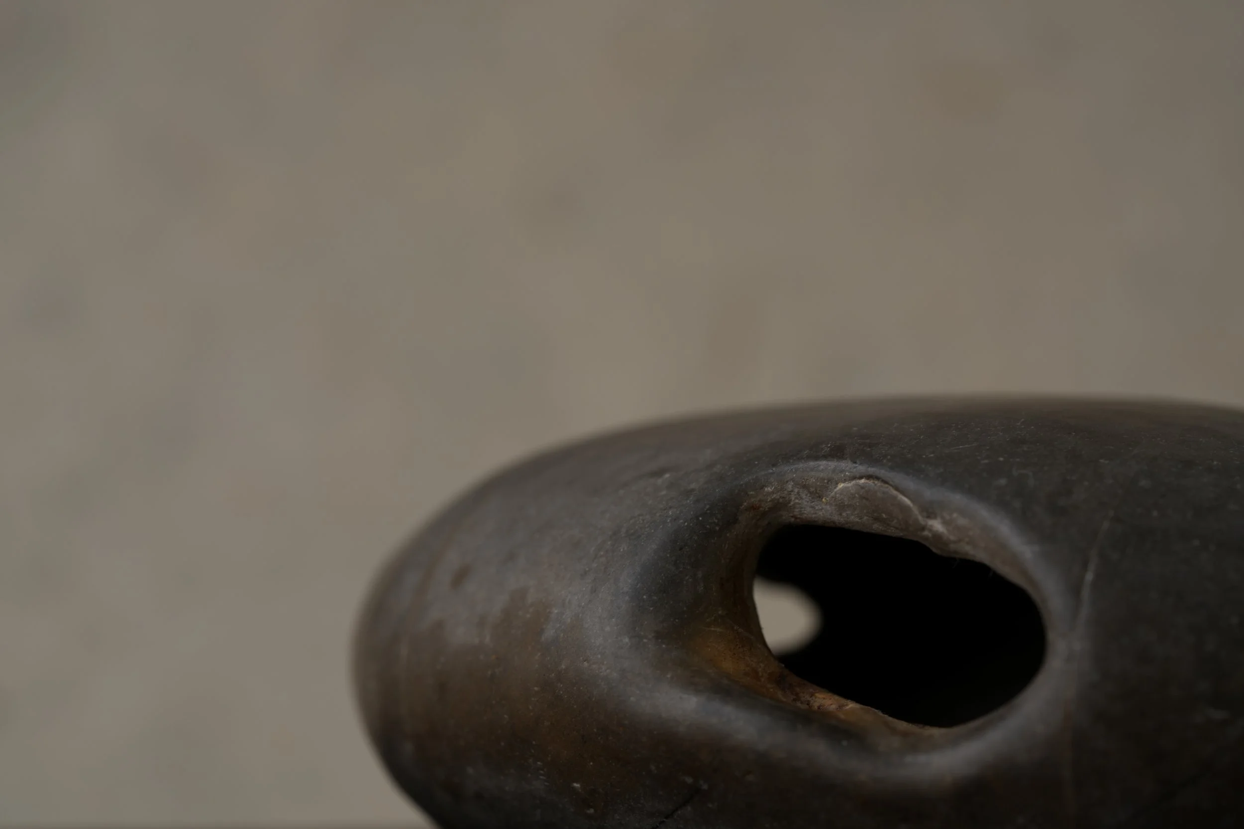 Close-up of a metallic pipe or cylindrical object with a dark hole or opening at one end.