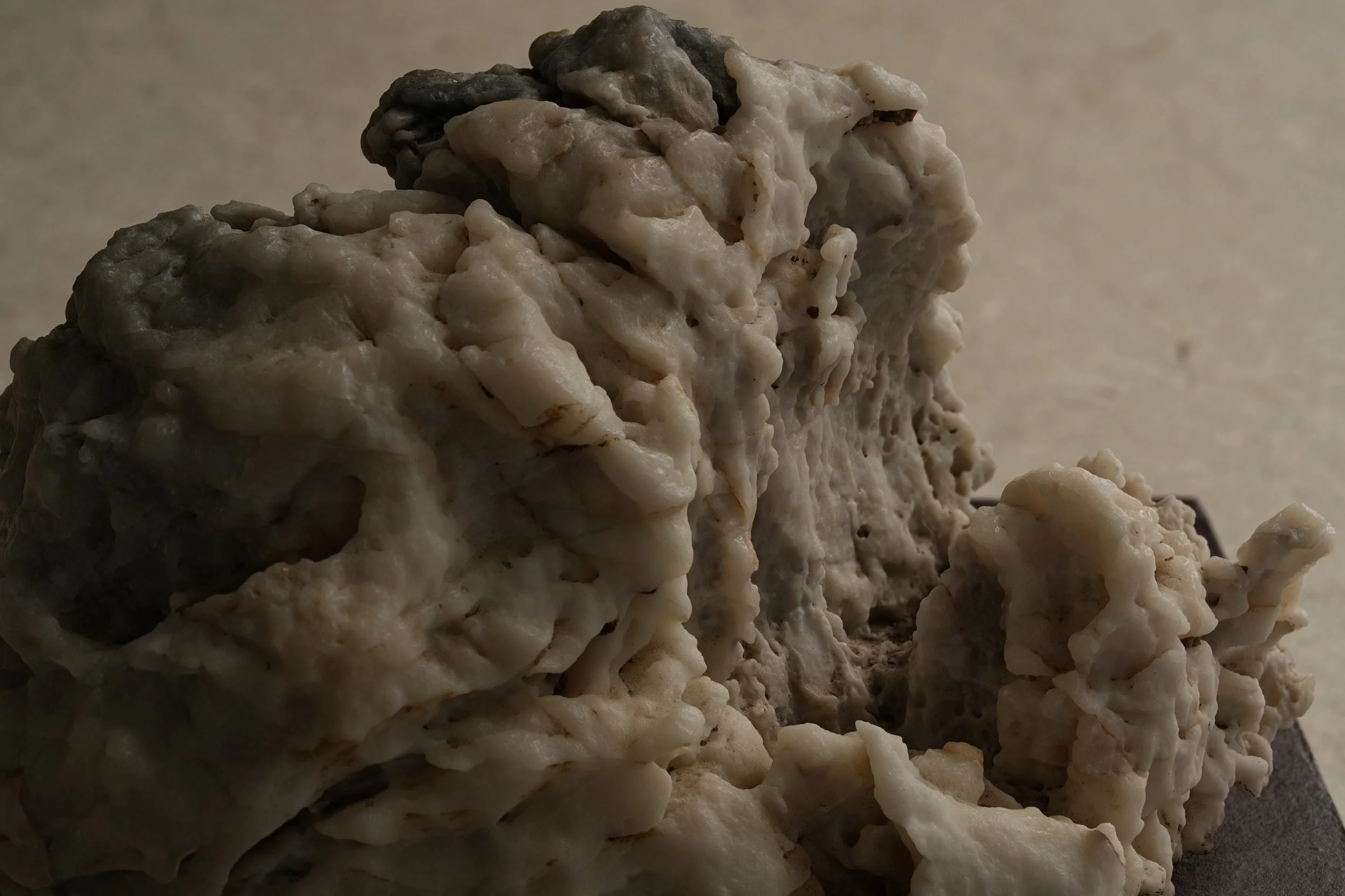 Close-up of a cluster of white and gray mineral or rock formations with a rough, porous texture.