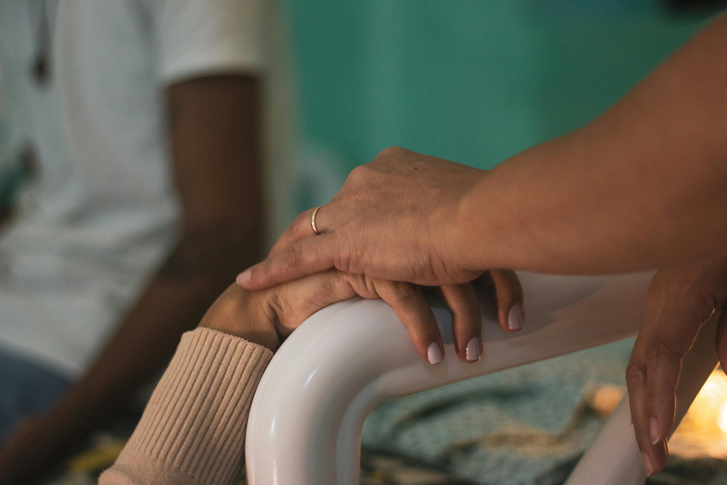 A doula holding a patient's hand in a hospital setting.