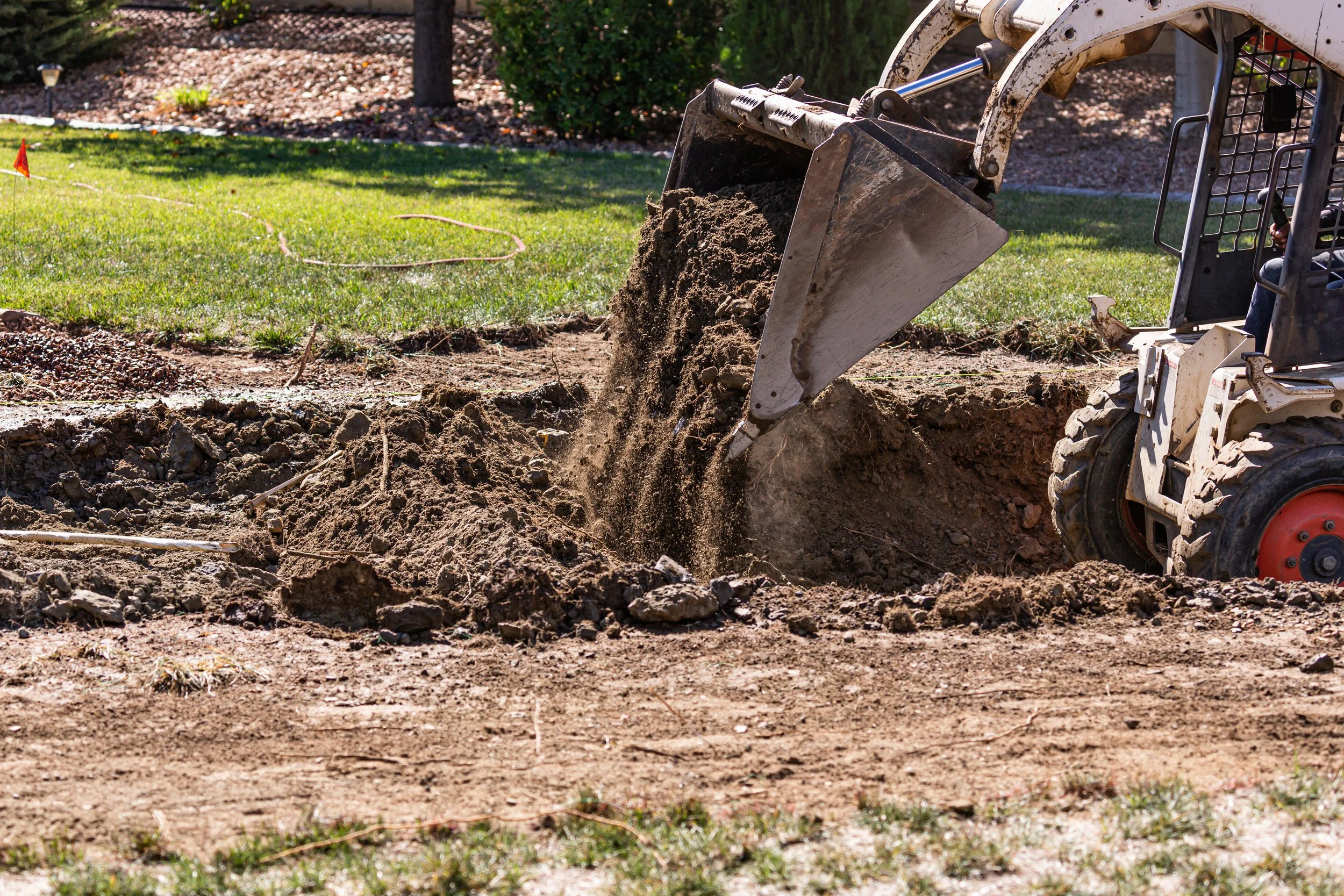 Excavation and grading work using heavy equipment to improve property drainage.
