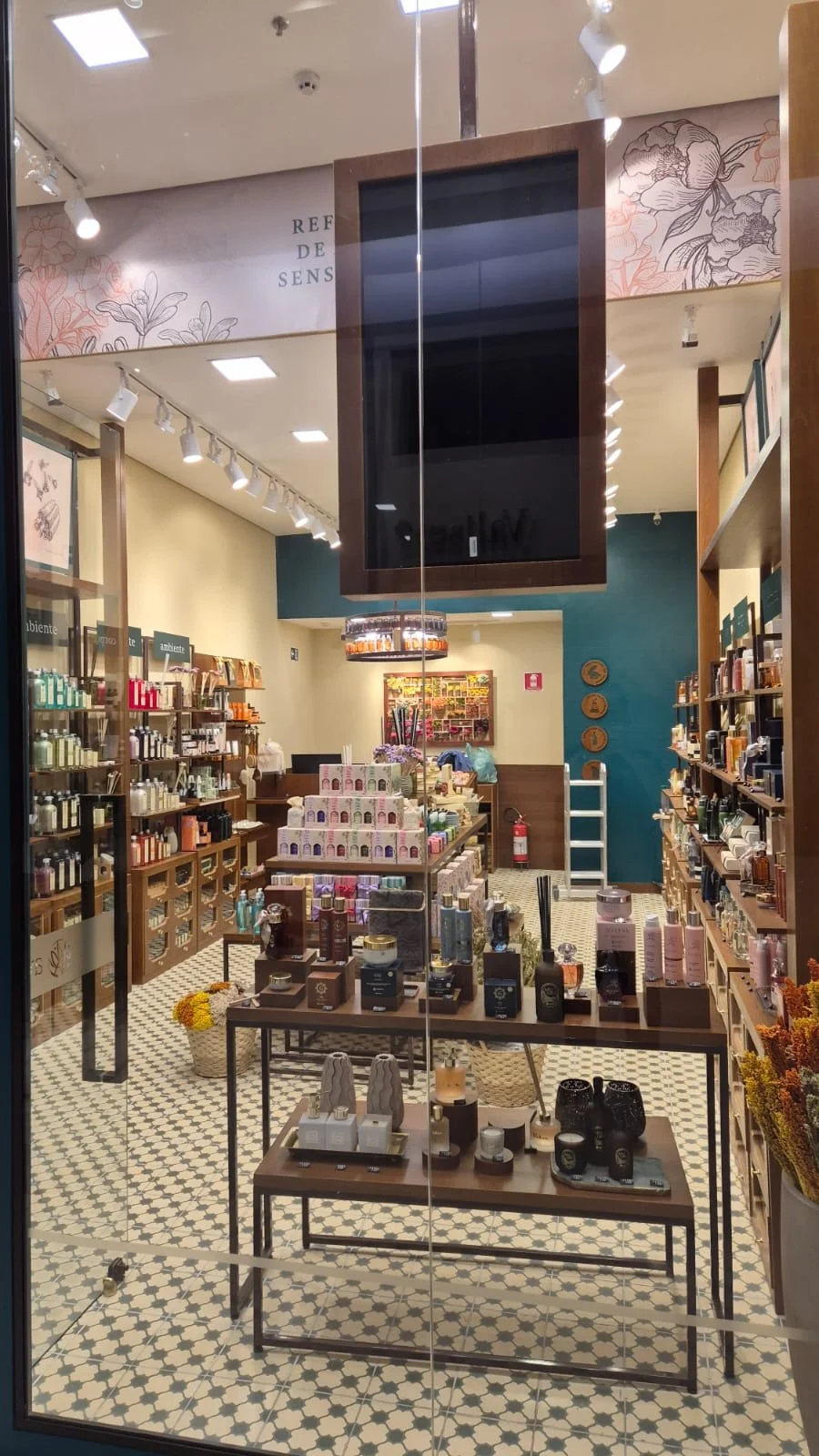 Interior de loja de produtos de beleza e cuidados pessoais, com prateleiras de diversos itens, expositores e decoração acolhedora.