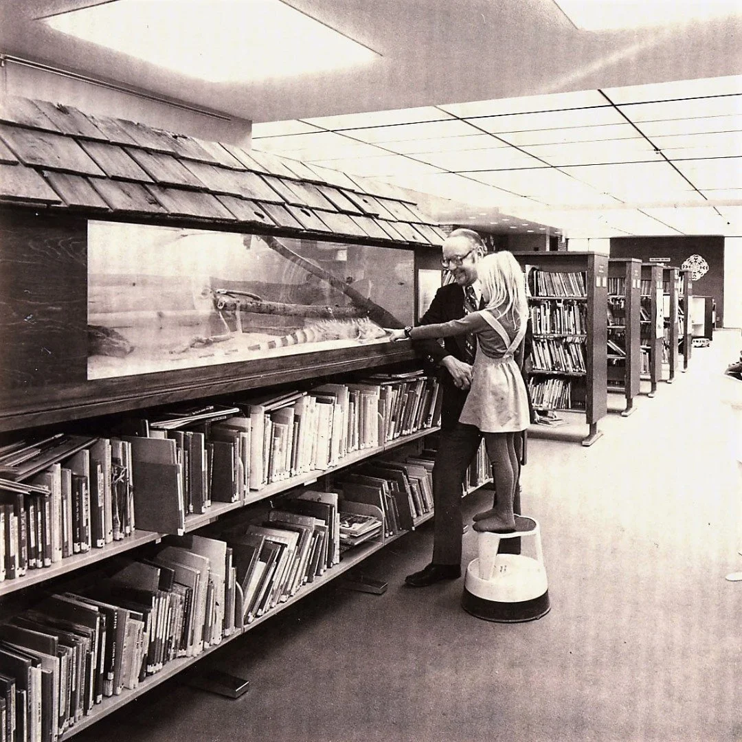 Fifty years of wonder captured in one curious glance. ✨

This 1973 snapshot of a young visitor mesmerized by an iguana at the Arlington Heights Memorial Library is a perfect reminder of how curiosity begins. 📸

In A Stroll Down Memory Lane, we look 