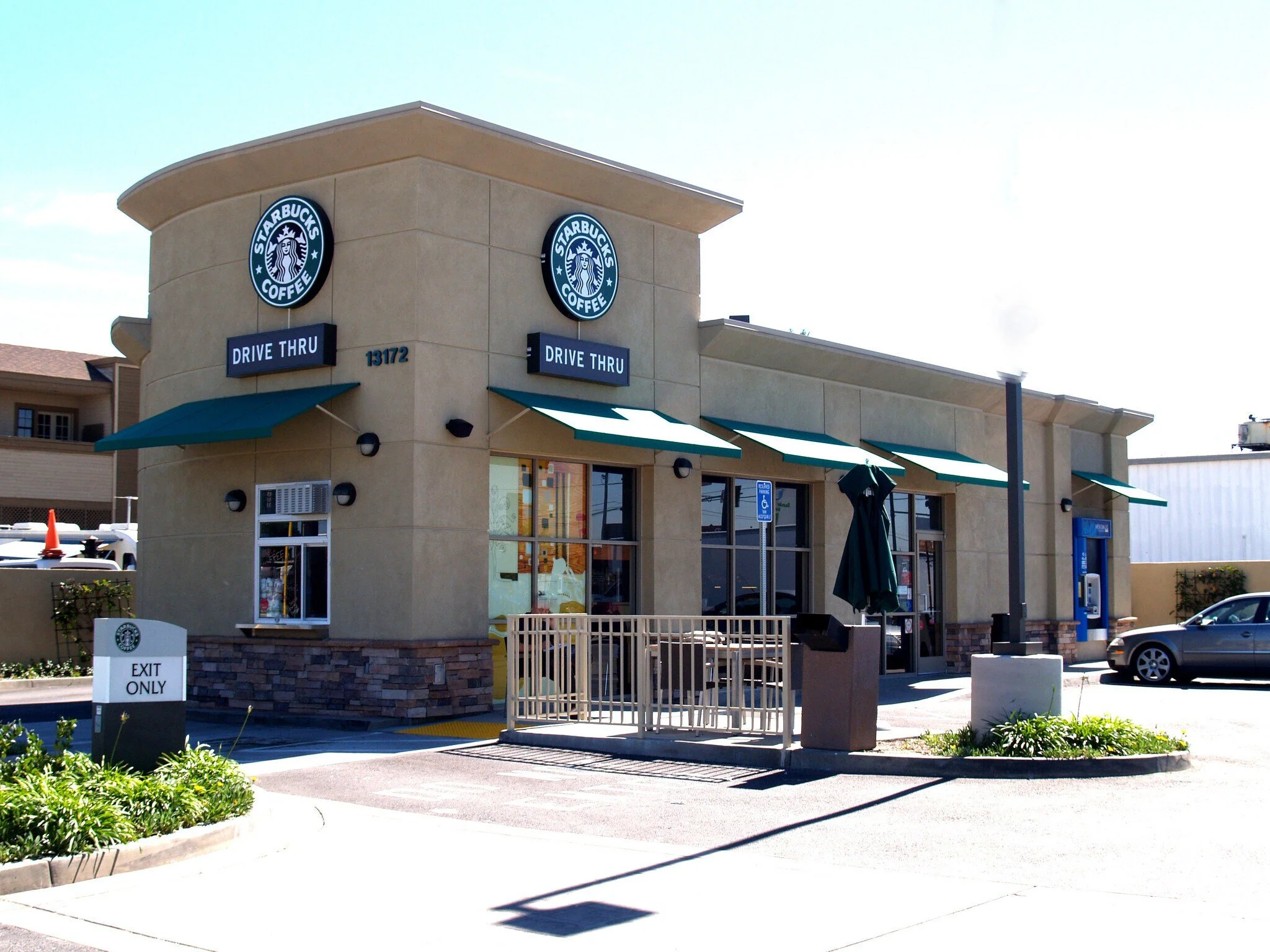 Starbucks coffee shop with drive-thru, outdoor seating in Orange County, CA.