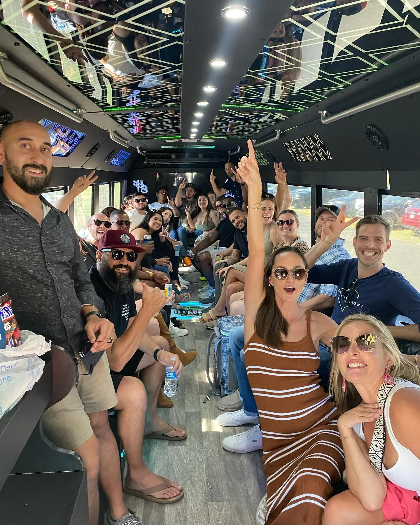 People riding a party bus, smiling and posing for a group photo.