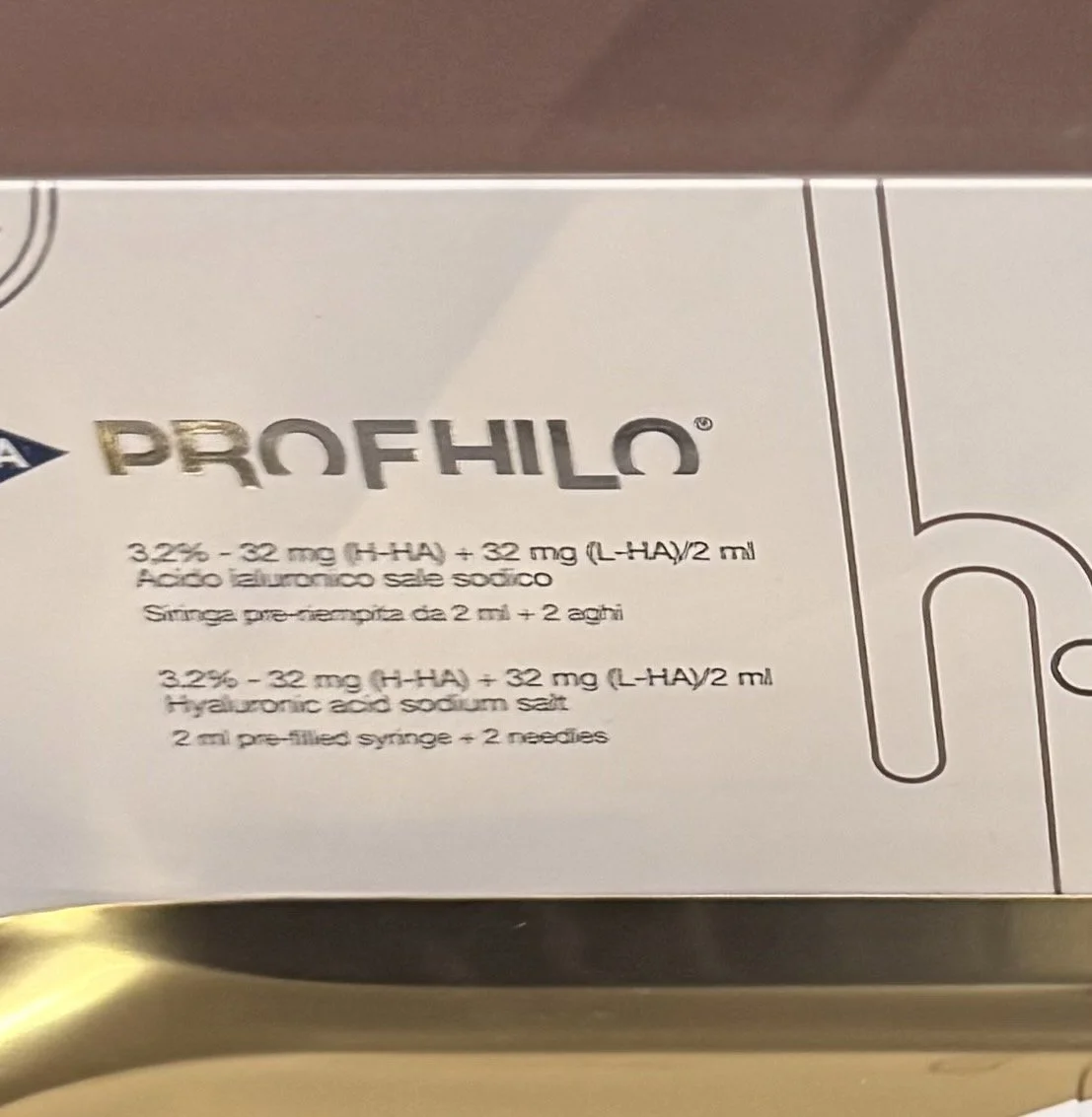 A gloved hand holding a syringe in a medical or laboratory setting.