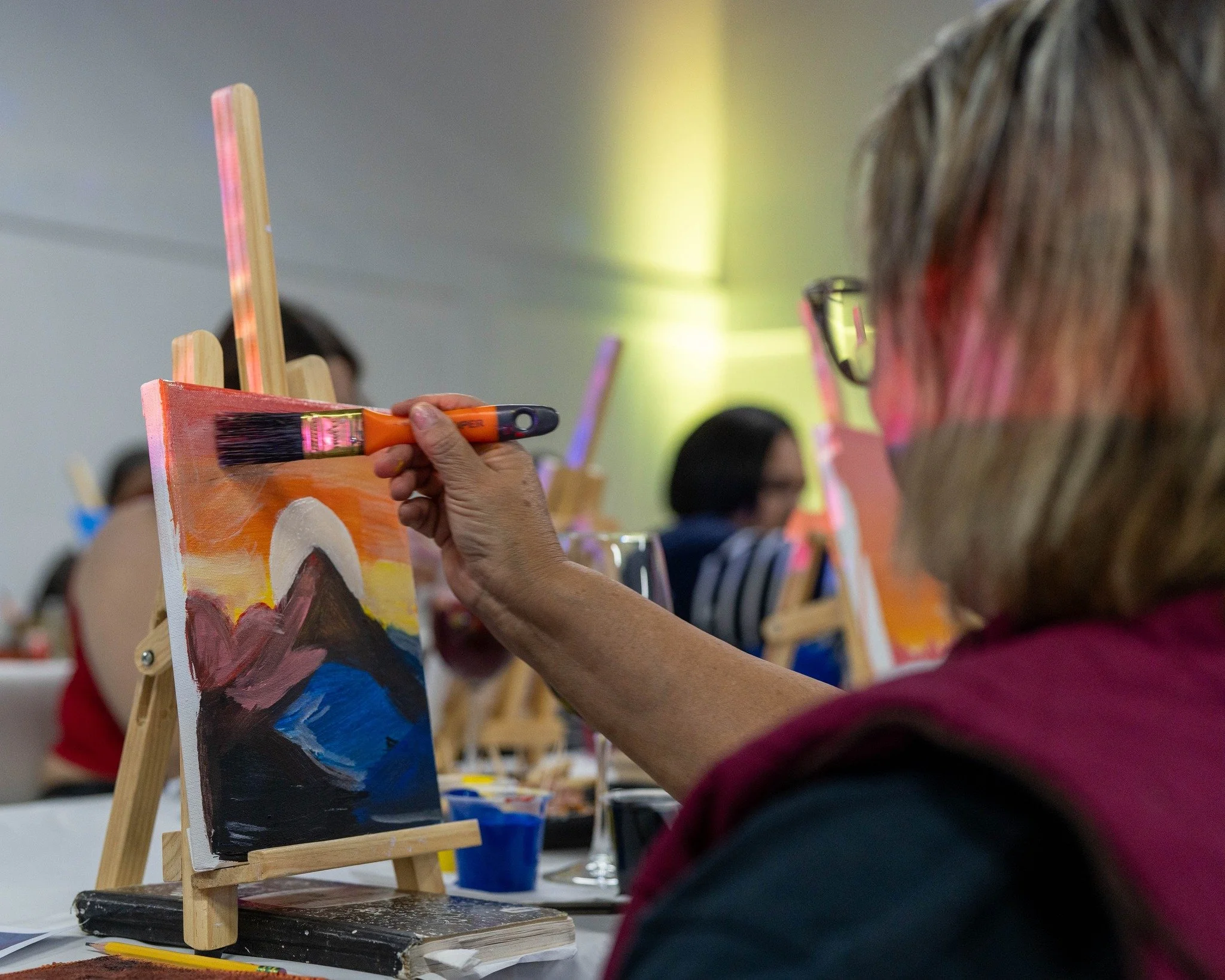 Participante realizando actividad de pintura en taller artístico comunitario.