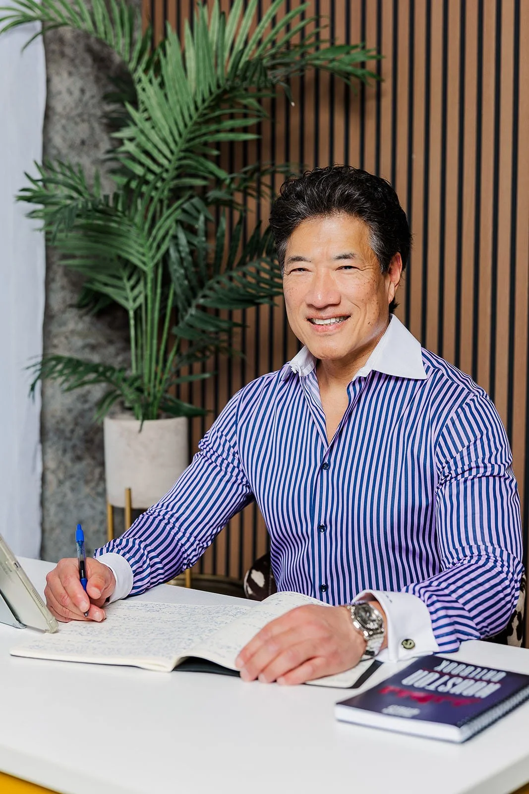 Dr. Kenneth Ro writing in notebook at desk