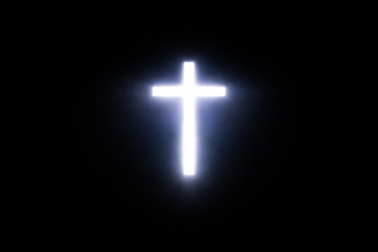 Bright cross-shaped light shining through a dark background.