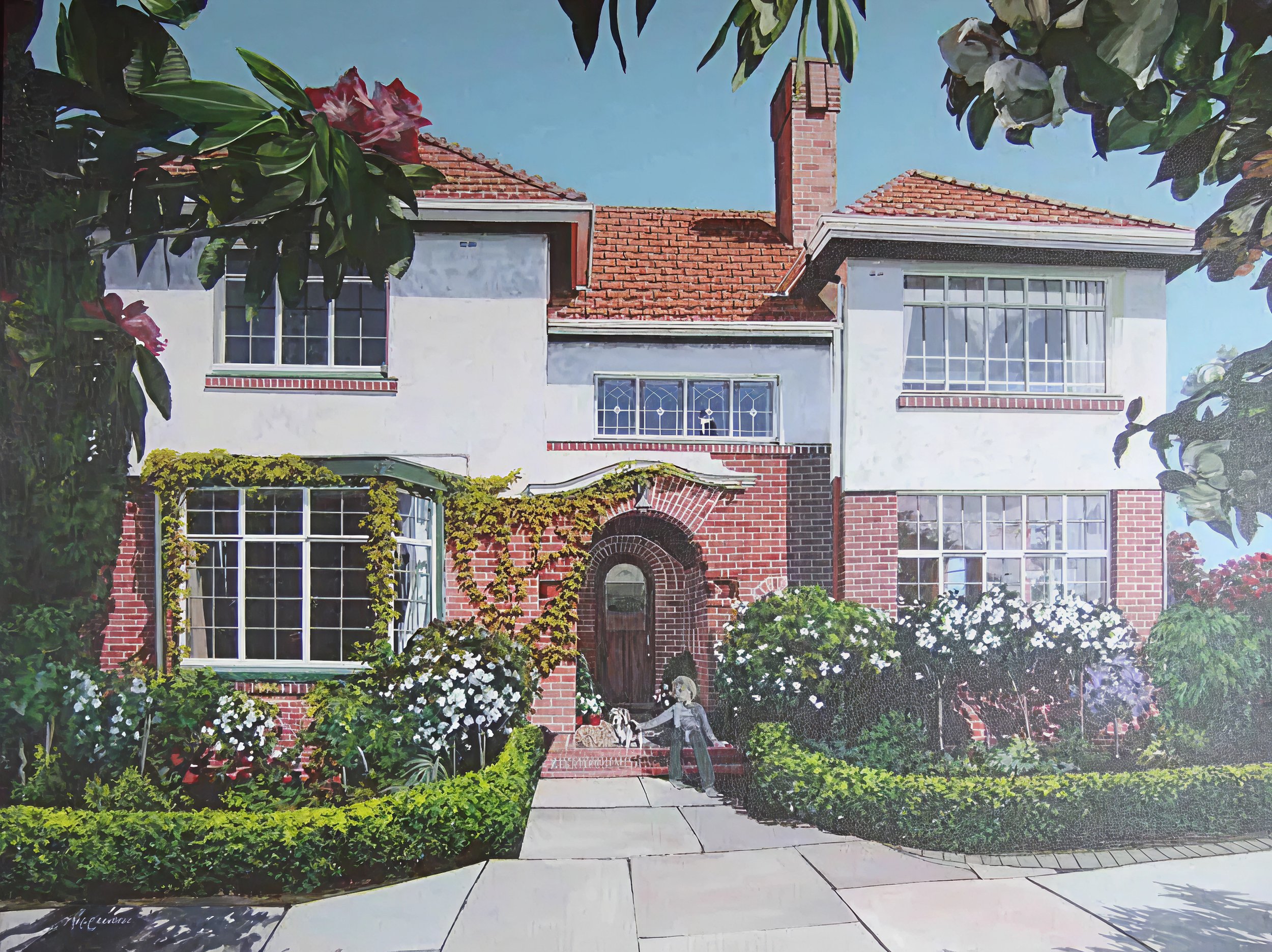 A large, two-story house with white walls and red brick accents, a red-tiled roof, and multiple windows. The front yard features lush green bushes, flowering plants, and ivy growing around the entrance. There is a person with a dog standing near the front steps of the house.