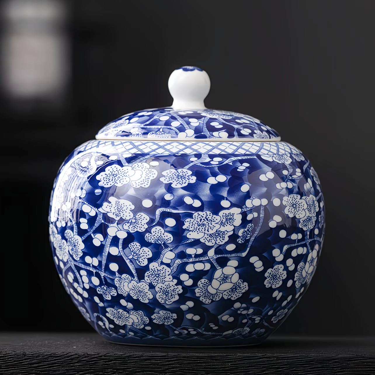 Close-up of a blue and white decorative porcelain jar with a lid, featuring floral and geometric patterns.