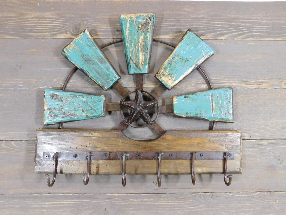 Decorative wall hanging with a star in the center, surrounded by blue distressed wooden panels, and hooks at the bottom on a wooden background.