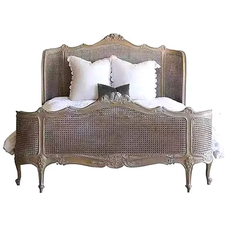 Vintage-style wooden bed with caned panels, white bedding, and decorative pillows.