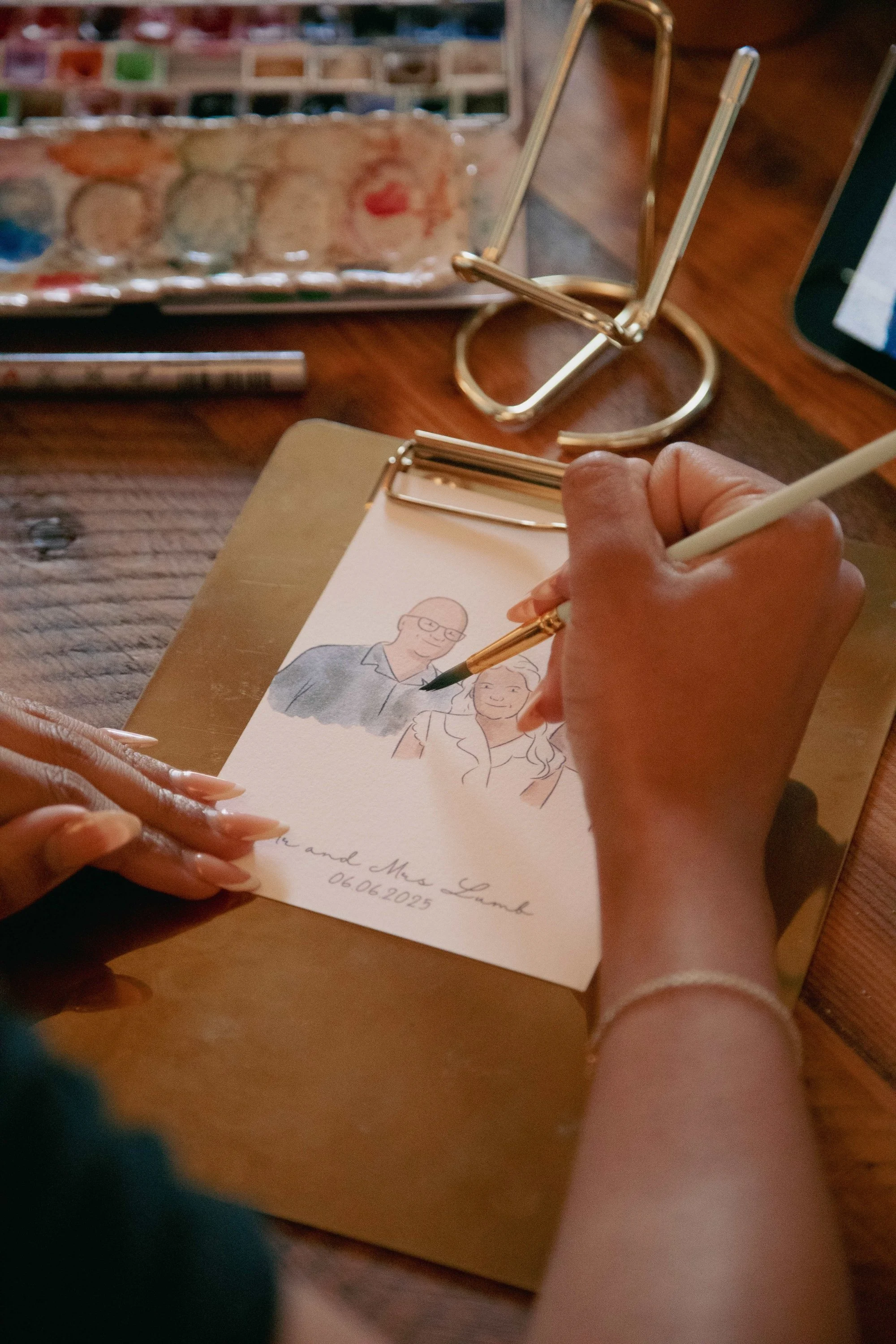 Person painting a custom illustrated wedding favour of guests