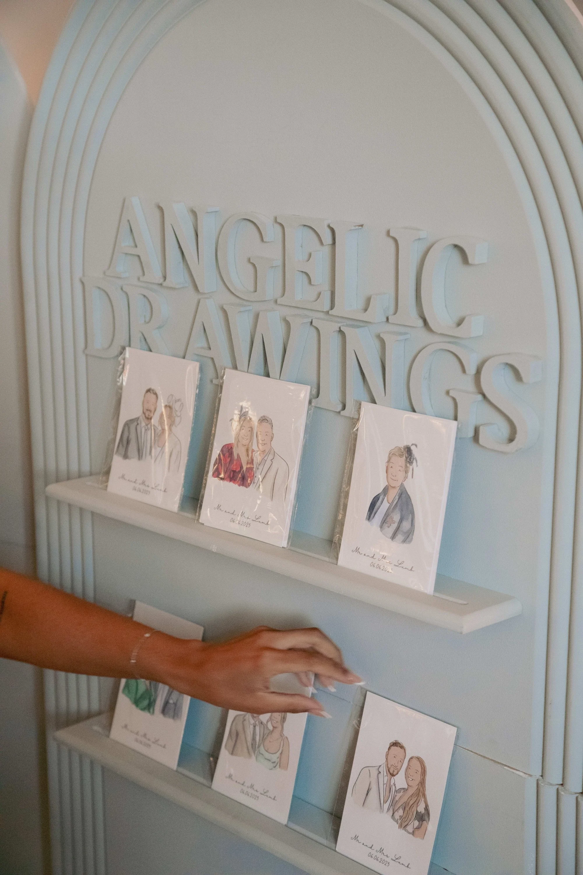 Display of custom illustrated wedding portraits on shelves