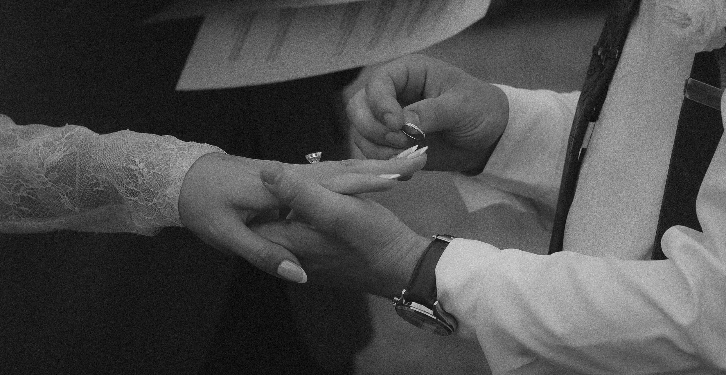 Close up of groom putting ring on brides finger