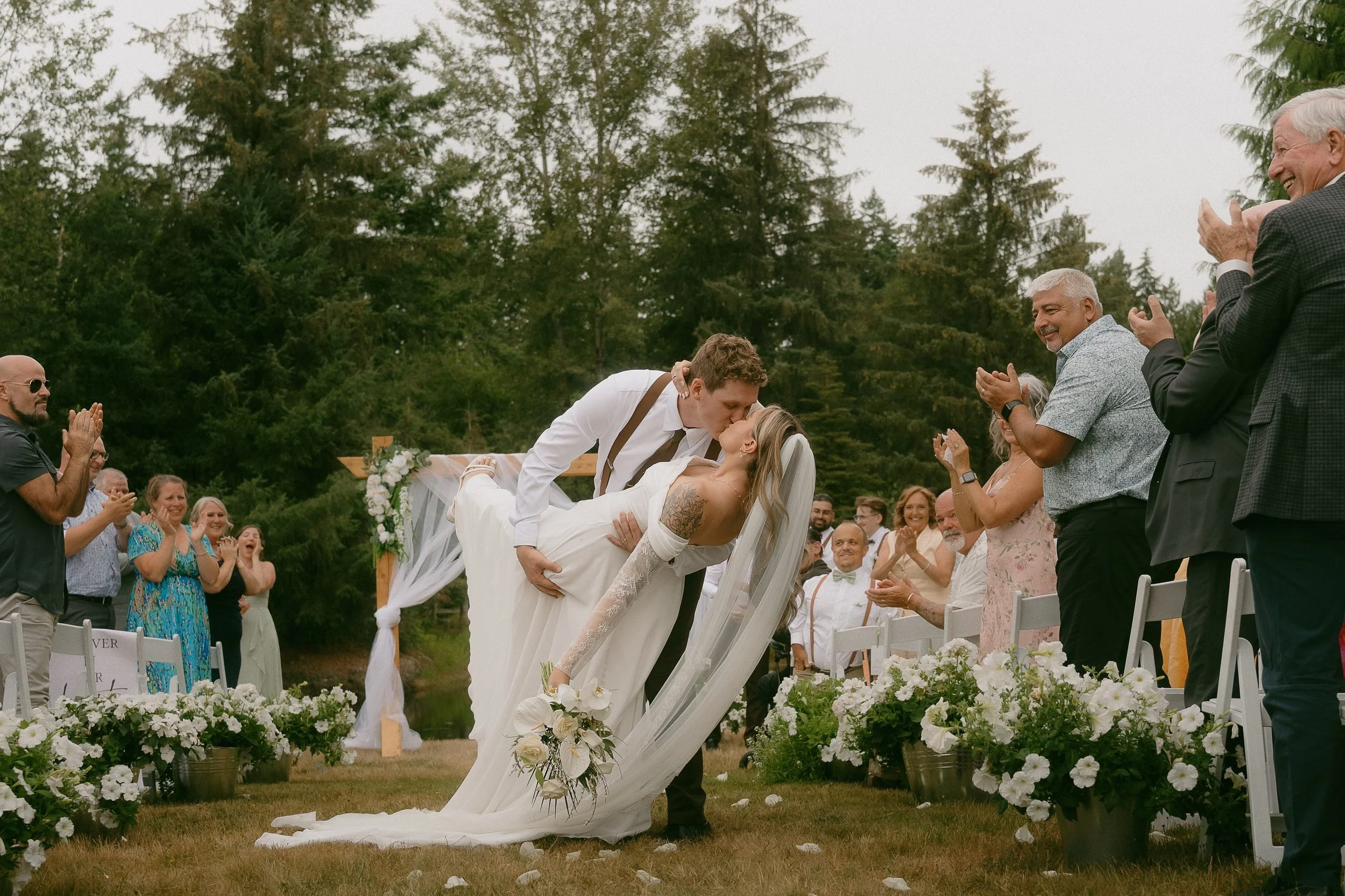 A newly married couple kissing after their outdoor ceremony, photographed by Summit and Sage