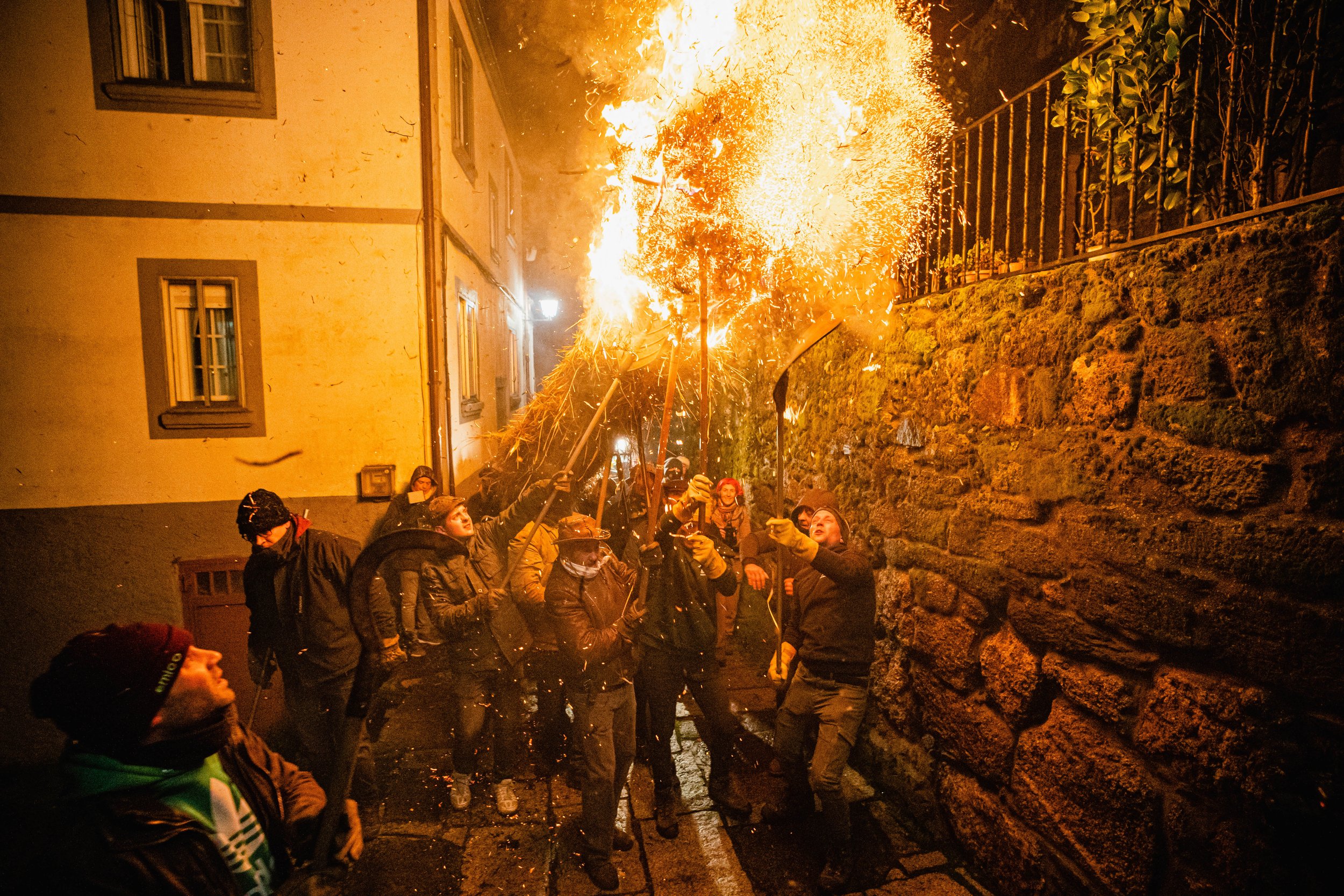 Residents transport a large straw torch, known as a “facho,” through the streets during the Festa dos Fachós in Castro Caldelas, on January 19, 2025.