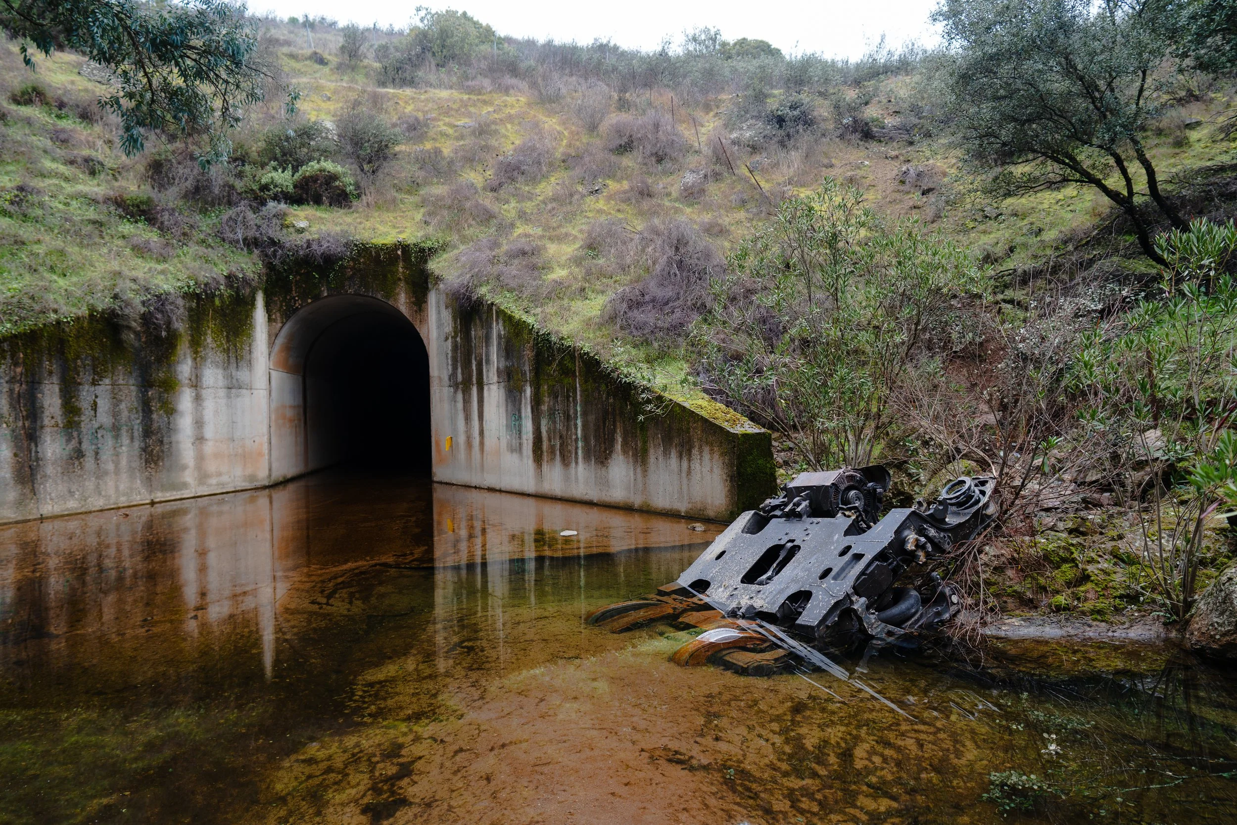 A damaged bogie lies in a stream beneath the tracks near the crash site, on January 21, 2026. The component was located the previous afternoon by a New York Times photographer; El Confidencial was the first Spanish outlet to reach the area where it w