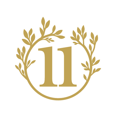 Gold monogram '11' inside a wreath of leaves on a black background.