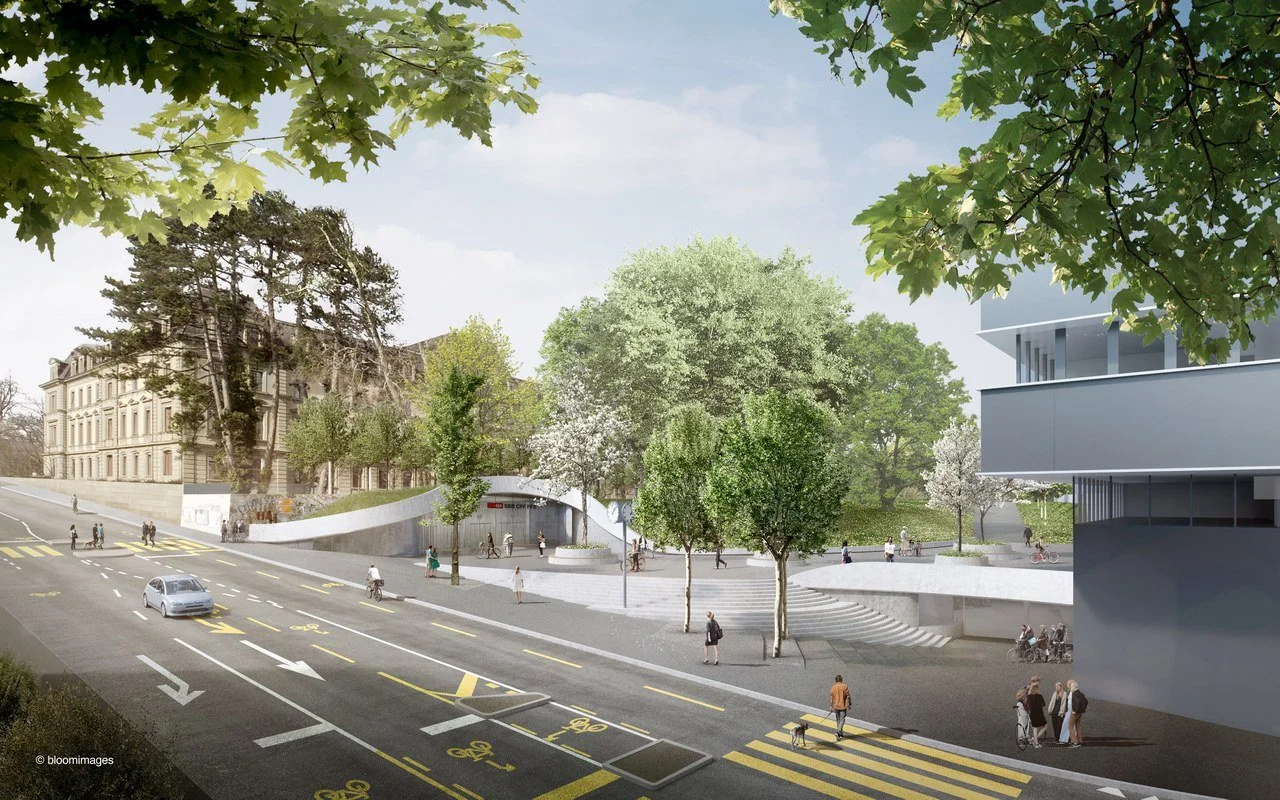 Stadtansicht mit Straße, Fußgängern, Fahrradfahrern und modernen Gebäuden, umgeben von Bäumen und einer grünen Parkanlage.