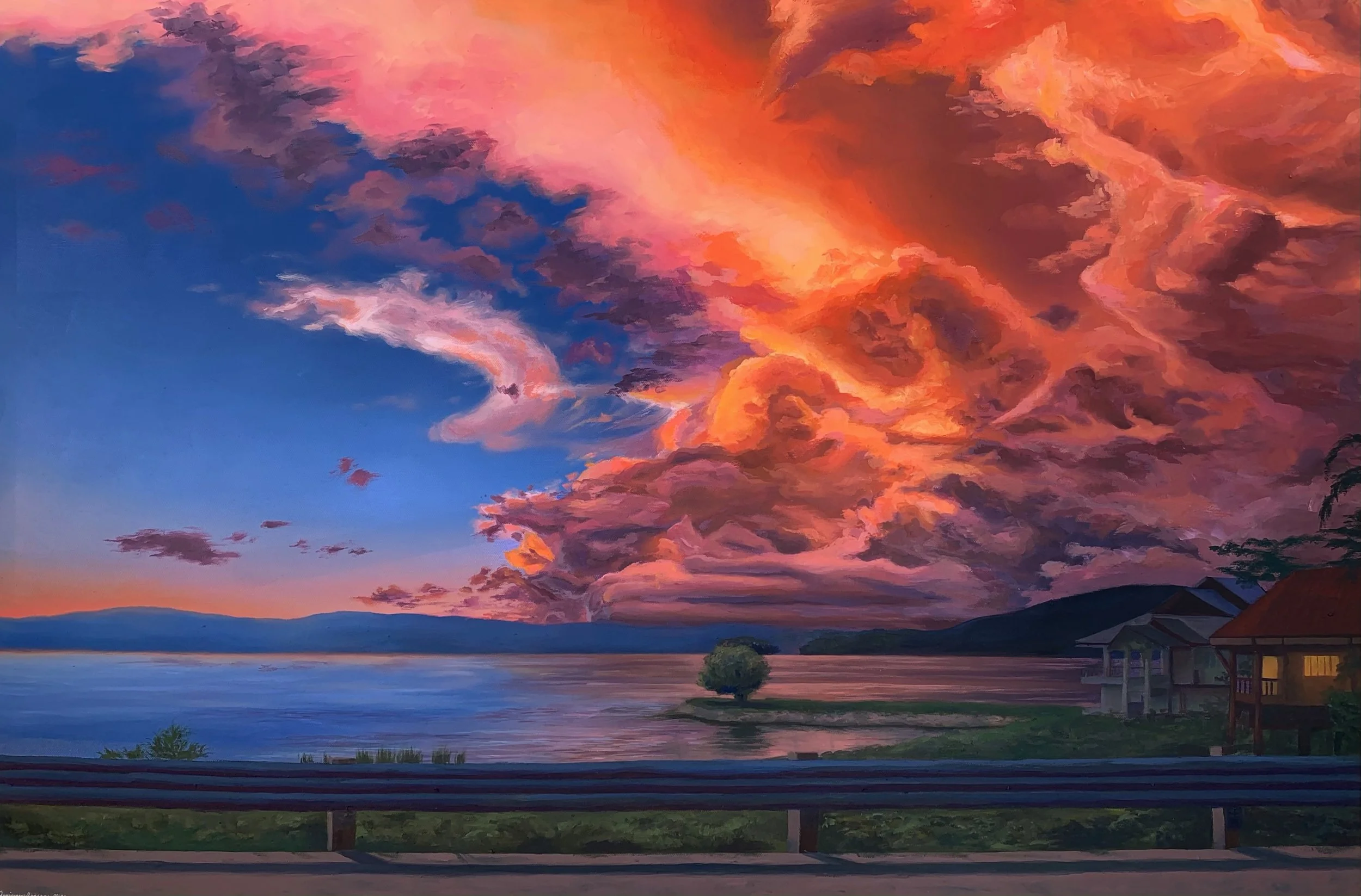 A vibrant sunset sky with dramatic pink and orange clouds over a calm lake, with distant mountains, a small tree on a tiny island, and houses on the shore in the foreground.
