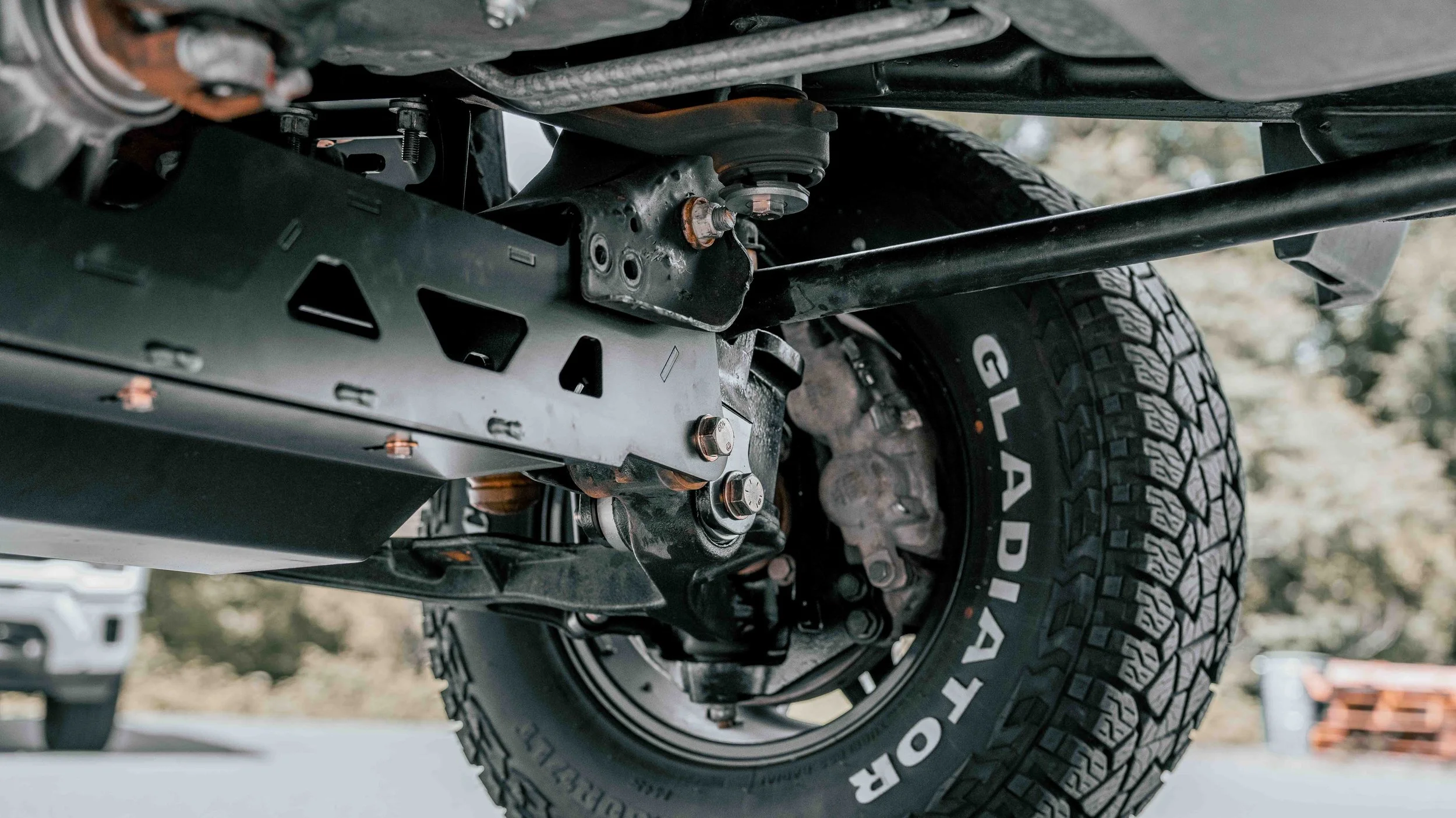 Undercarriage view of a lifted GMC Sierra showing ReadyLIFT suspension components and Gladiator tires after installation.