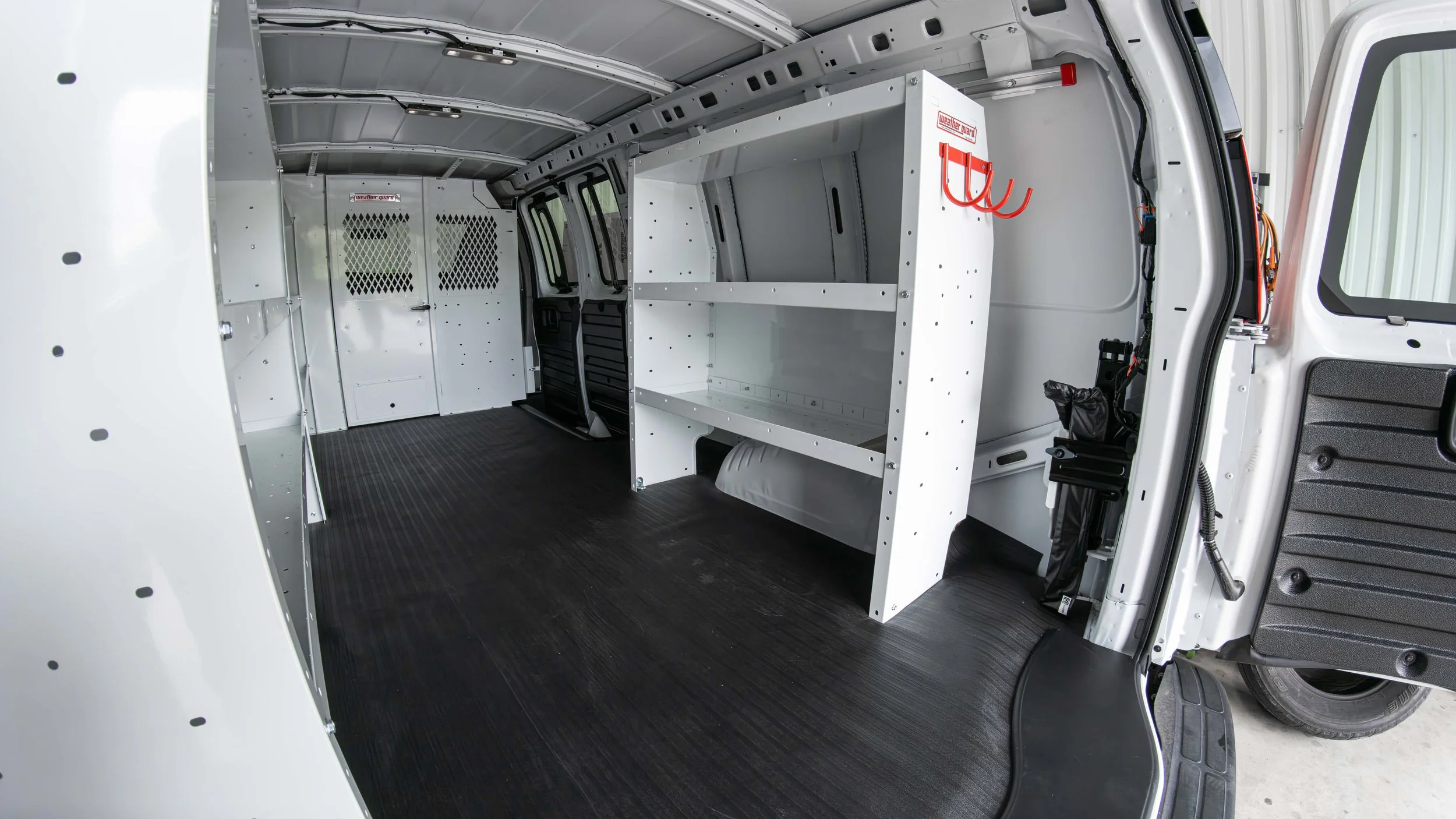 Finished WeatherGuard shelving build in a Chevy Express work van photographed from the rear passenger side at Xtreme in Bridgeville, PA
