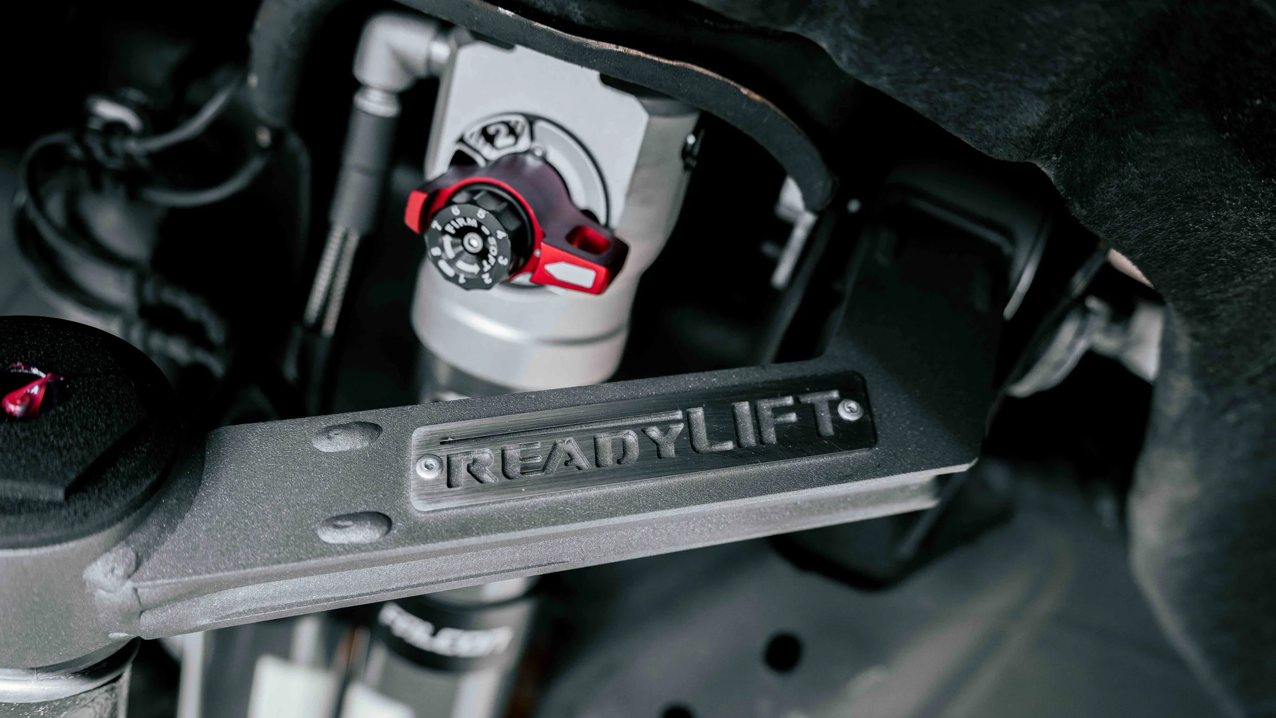 Close-up of ReadyLIFT upper control arm and Falcon 3.3 shock hardware on a GMC Sierra lift kit installation in Bridgeville, PA.