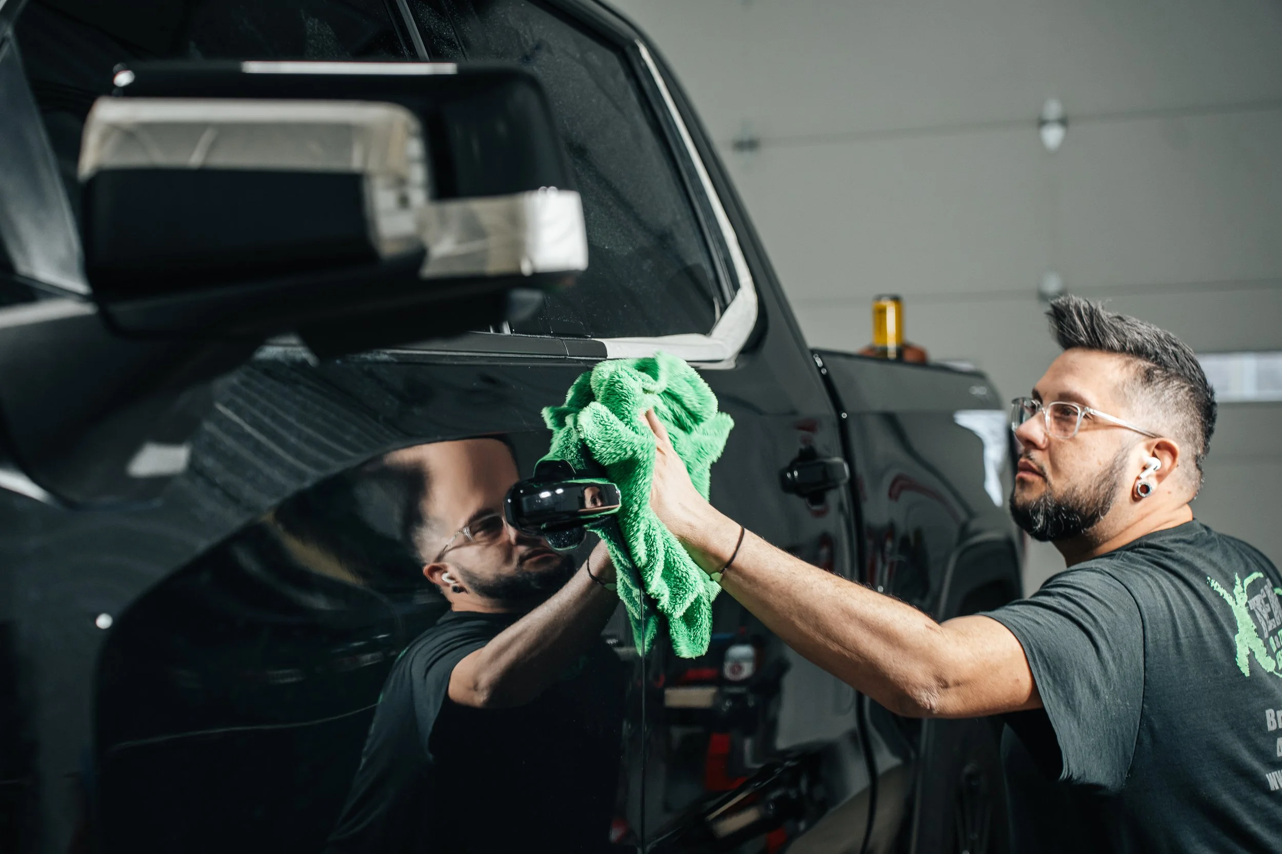 Technician machine polishing black truck during paint correction at Xtreme Car & Truck Accessories in Bridgeville, PA