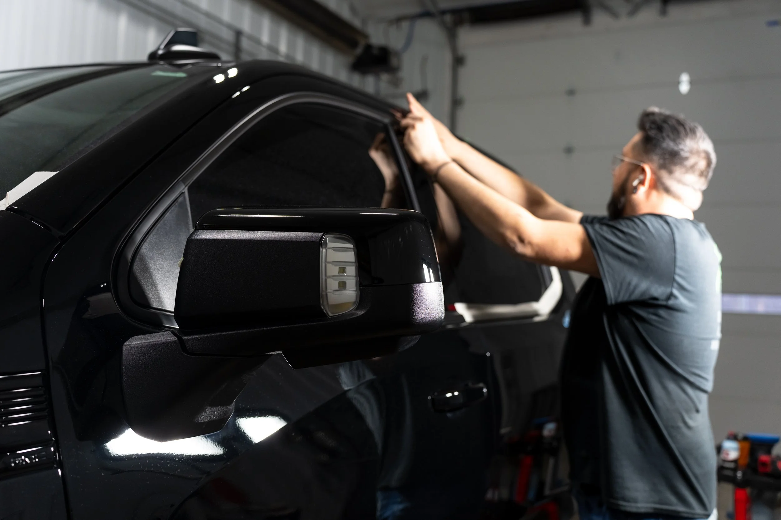 Technician machine polishing black truck during paint correction at Xtreme Car & Truck Accessories in Bridgeville, PA