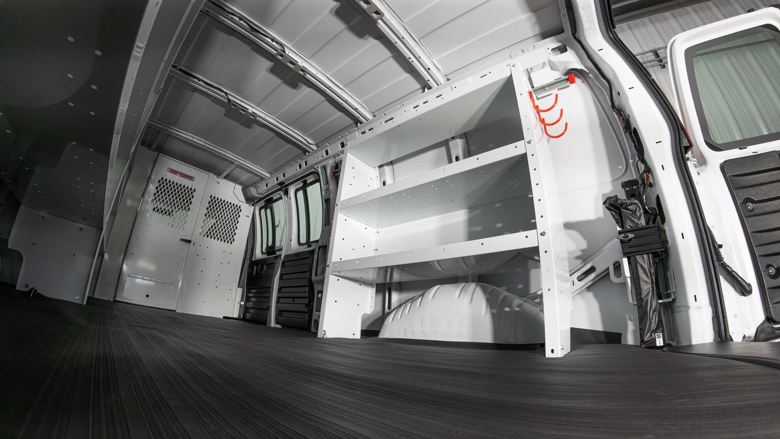 Low-angle interior shot of WeatherGuard shelving and open cargo floor inside a Chevy Express van