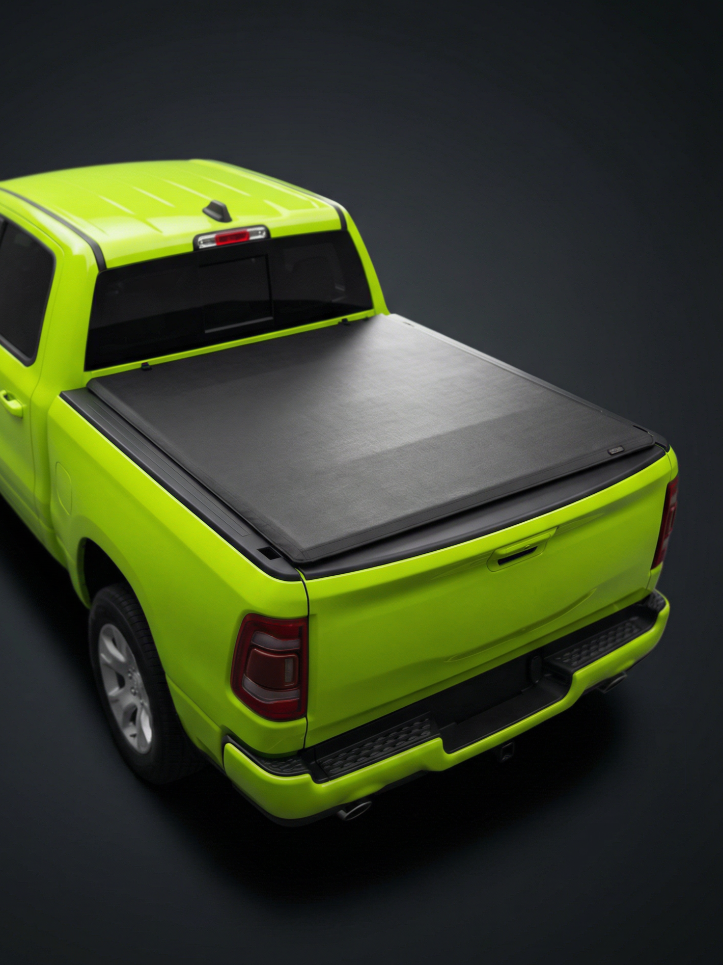 A neon green pickup truck with a black tonneau cover over the bed, shown from above on a dark background.