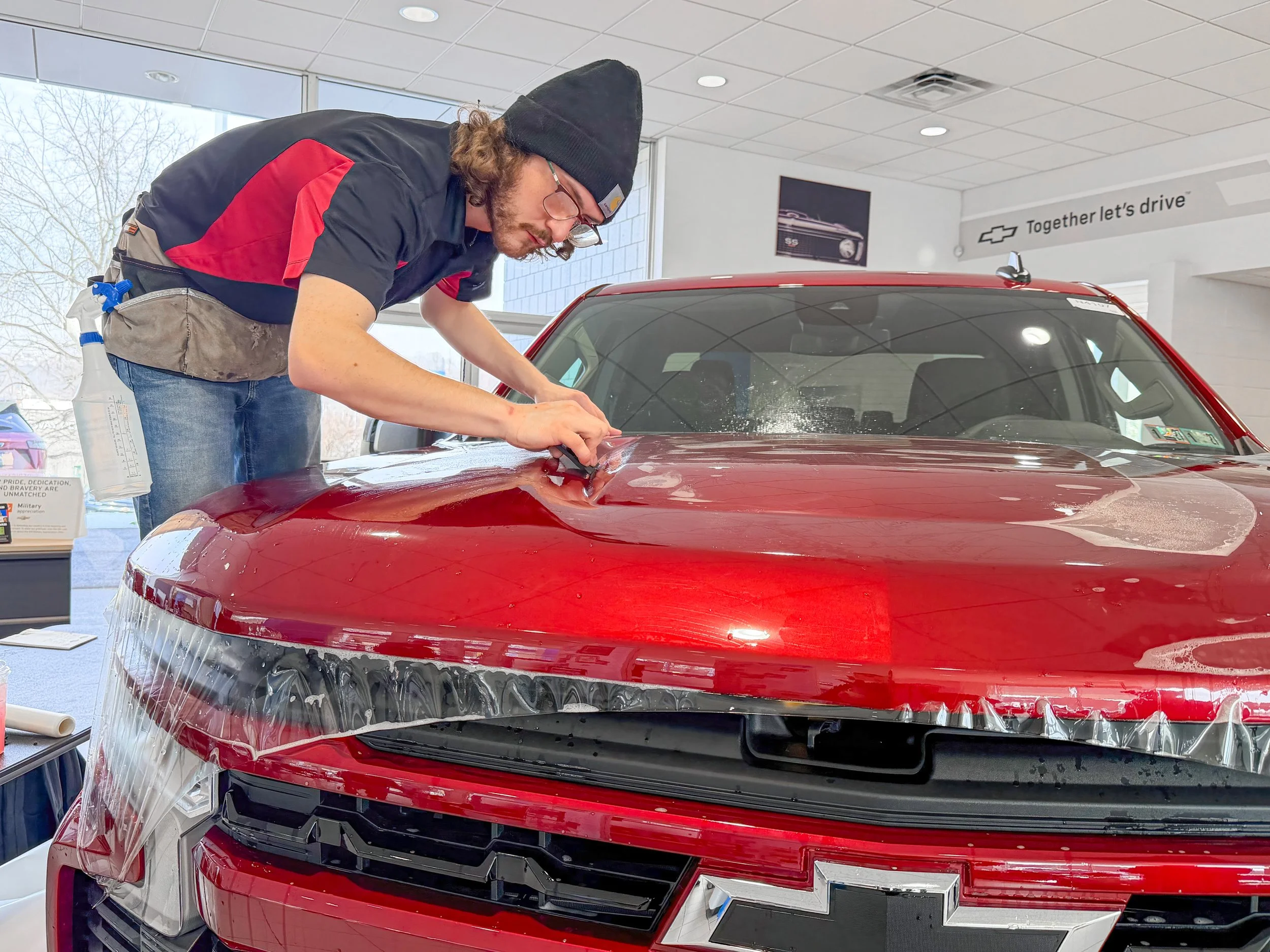 Paint protection film installation on the hood of a red Chevy truck by Xtreme Car and Truck Accessories near Pittsburgh.