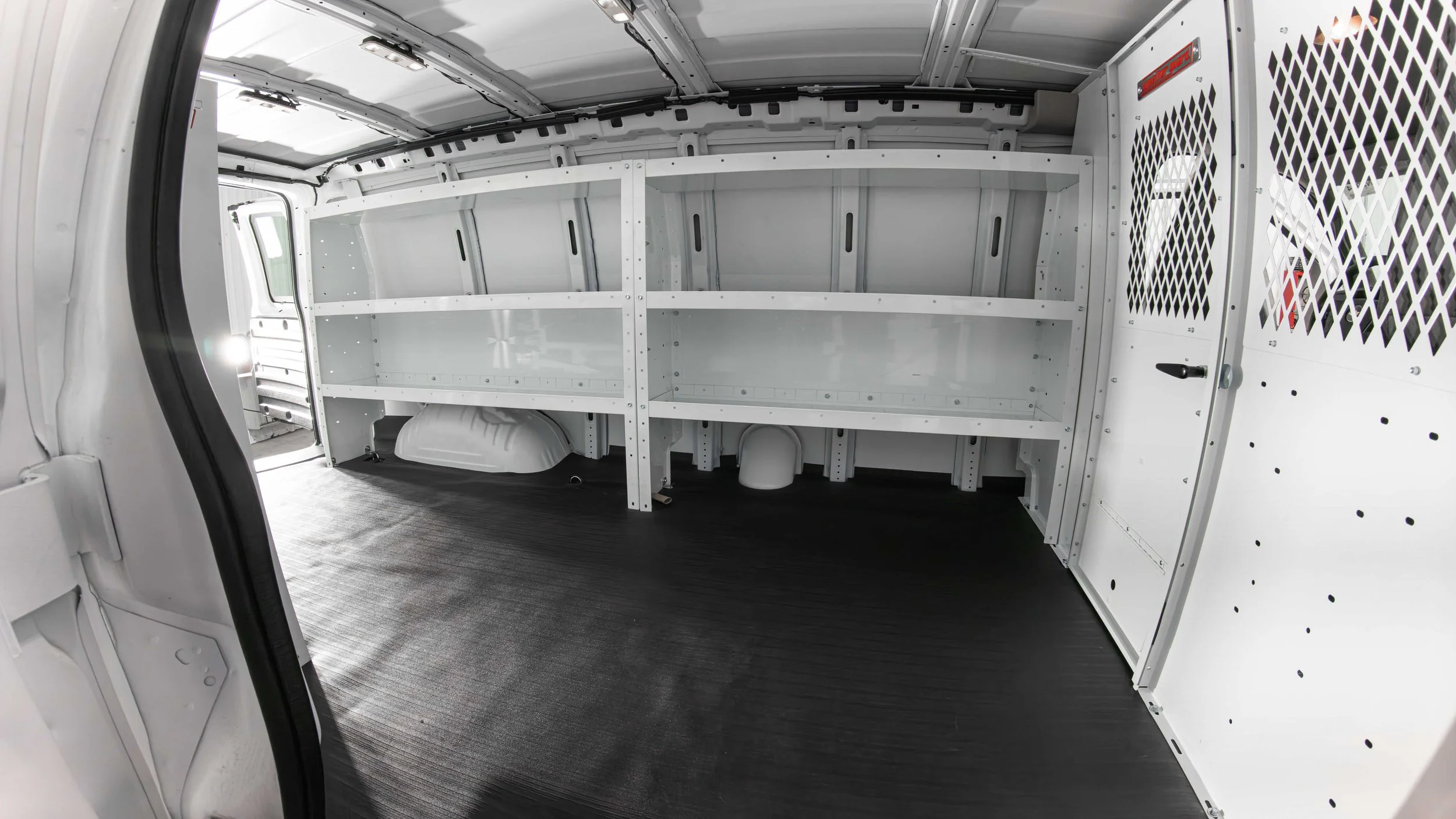 Long WeatherGuard side shelves and a screened partition running the length of a Chevy Express cargo van