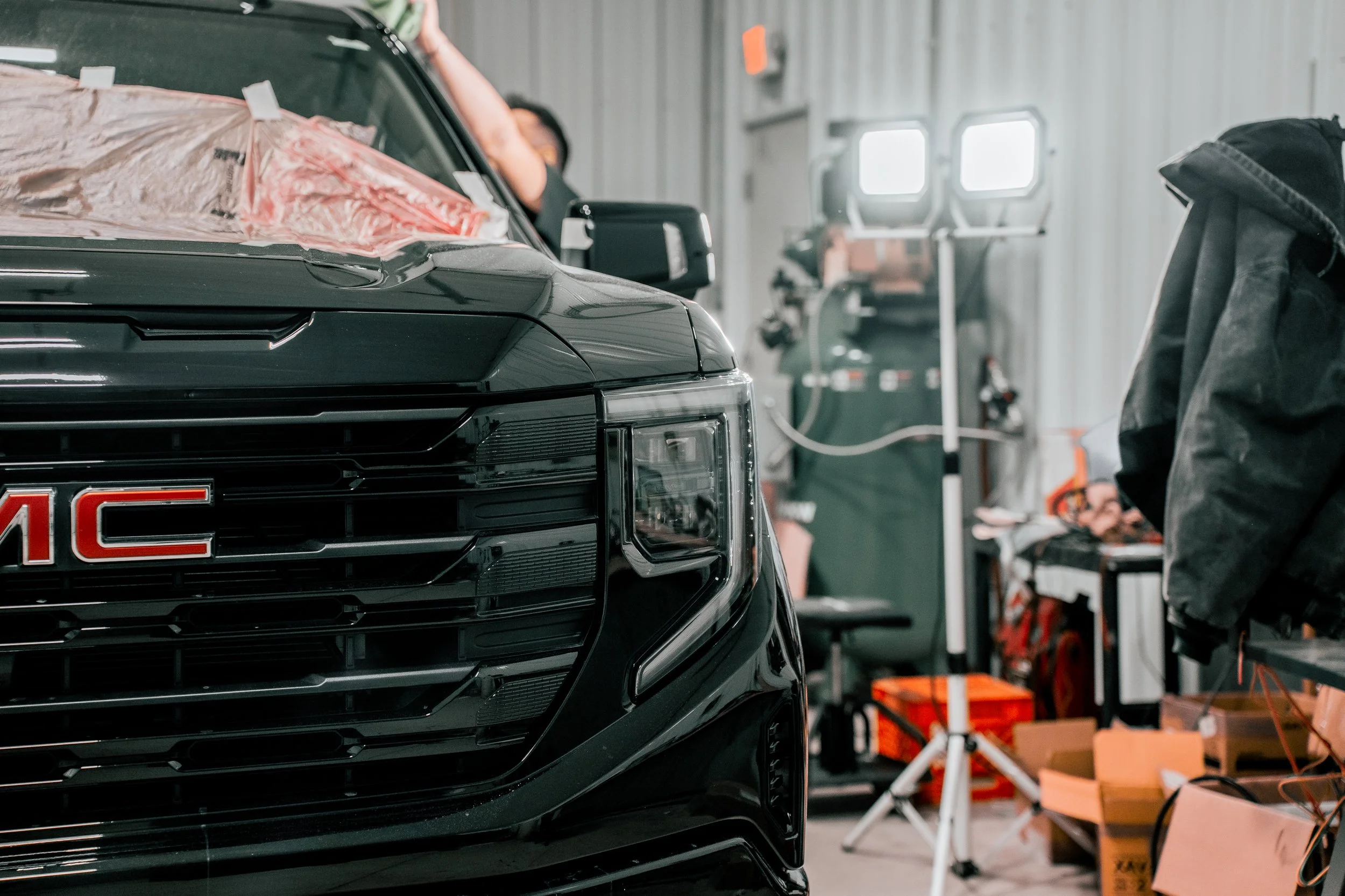 Paint correction service in progress on black GMC truck inside Xtreme shop in Bridgeville, PA — South Hills Pittsburgh