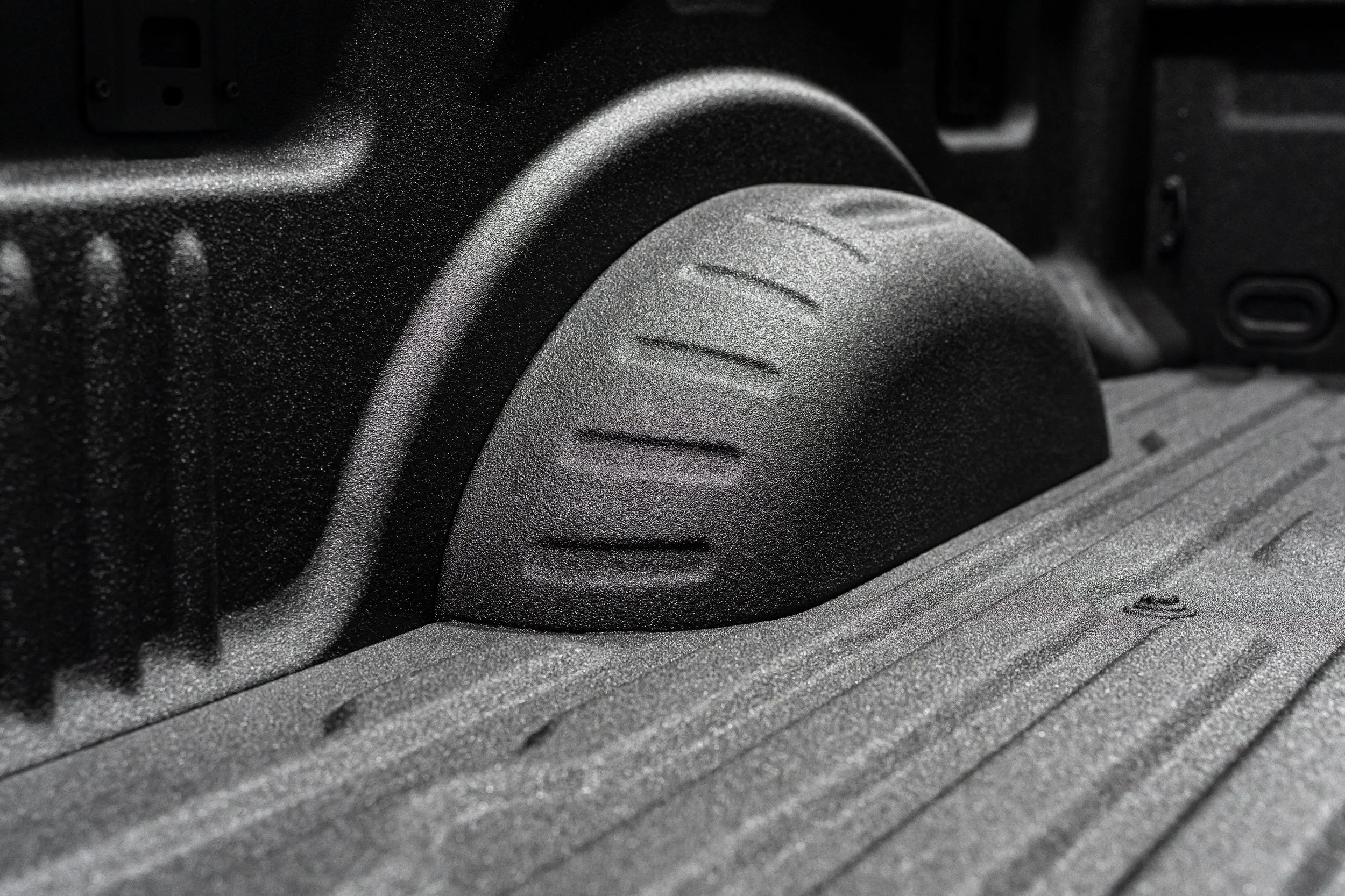 Spray-in bed liner coating bonded over the wheel well and contours of a pickup truck bed at Xtreme Car & Truck Accessories near Pittsburgh, PA.
