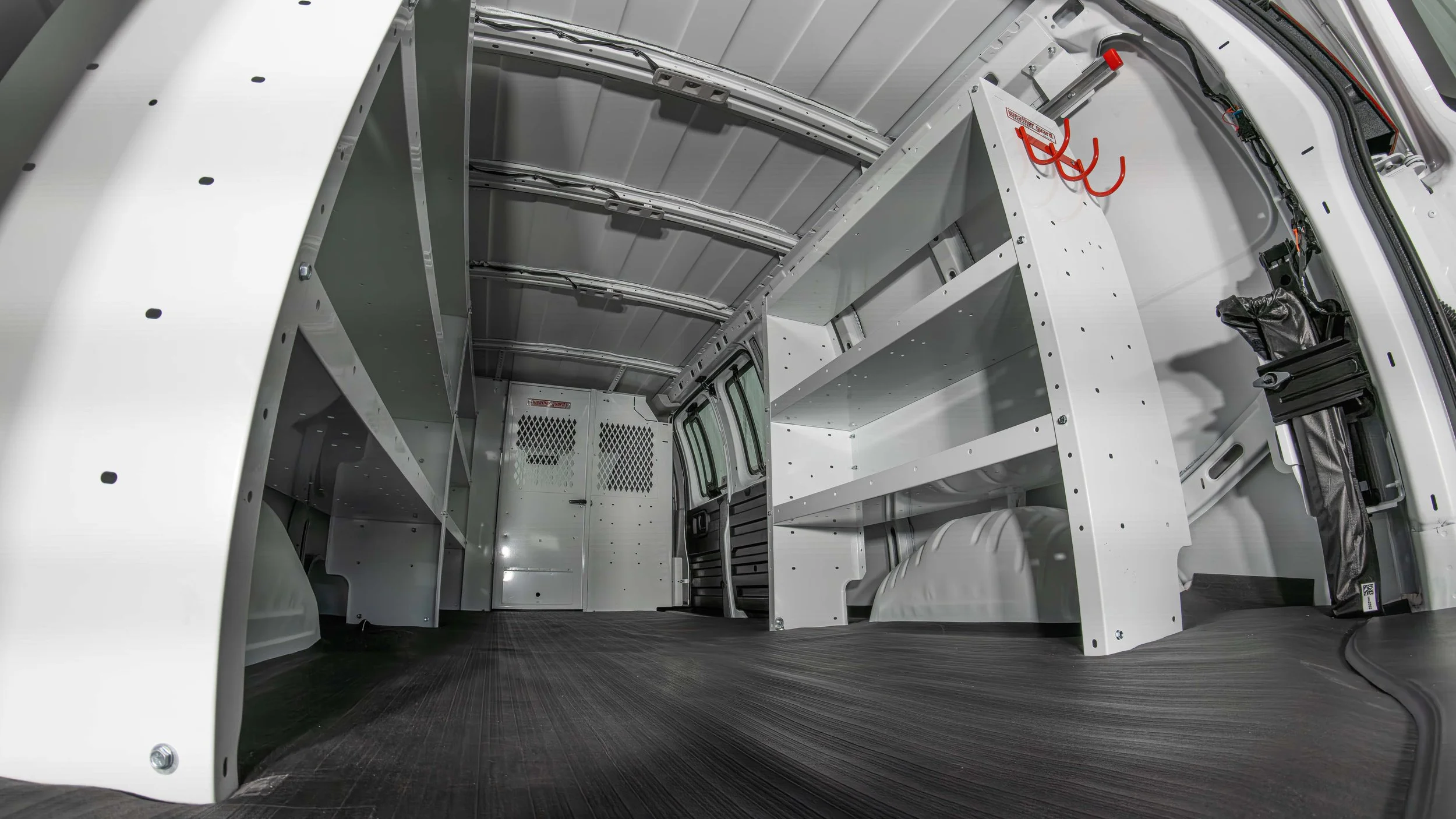 Interior cargo area of a Chevy Express van showing WEATHER GUARD shelving, red tool hooks, and work van organization