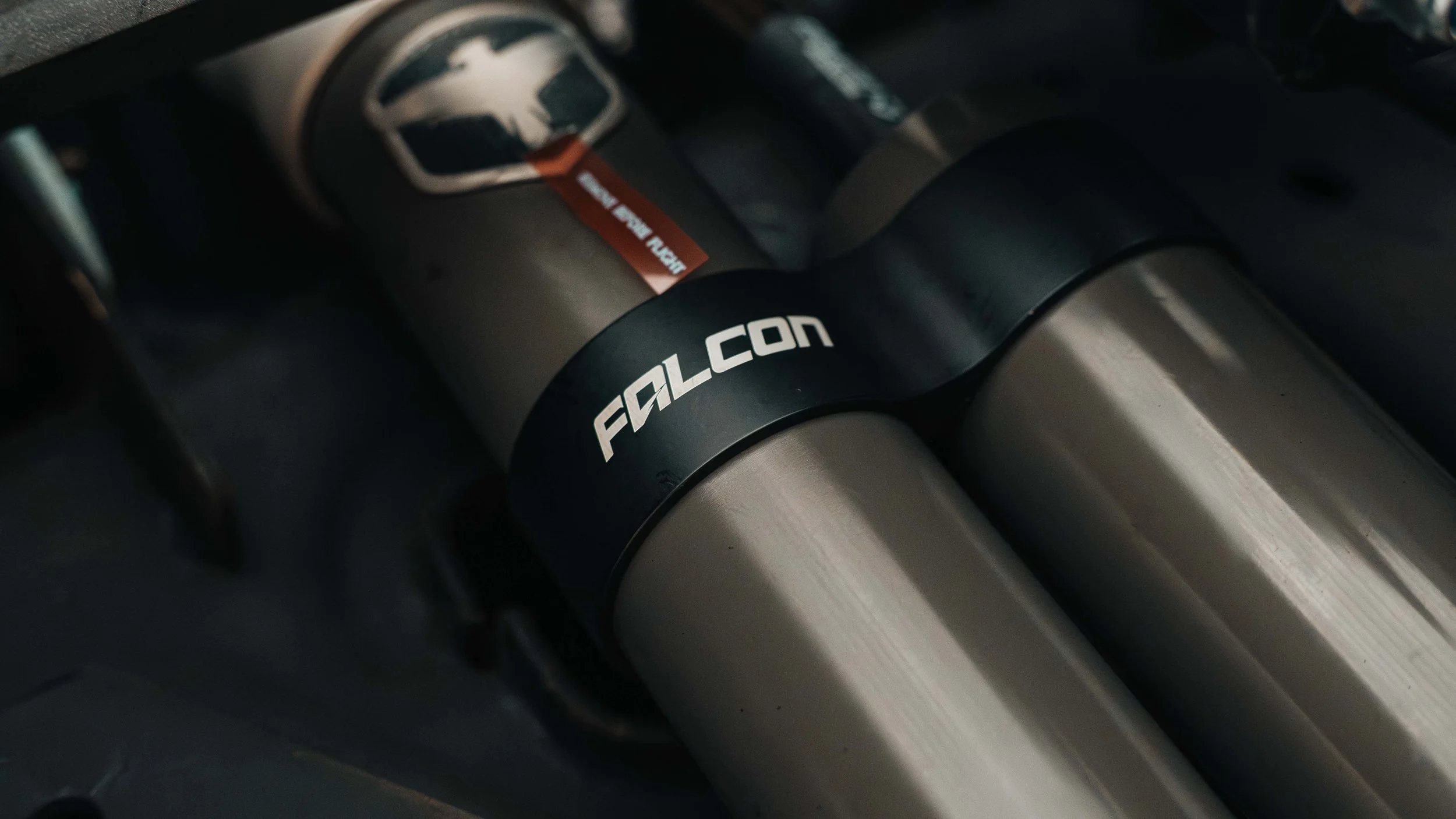 Close-up of Falcon shock reservoirs installed as part of a ReadyLIFT 6-inch MAX3 GMC Sierra suspension lift.