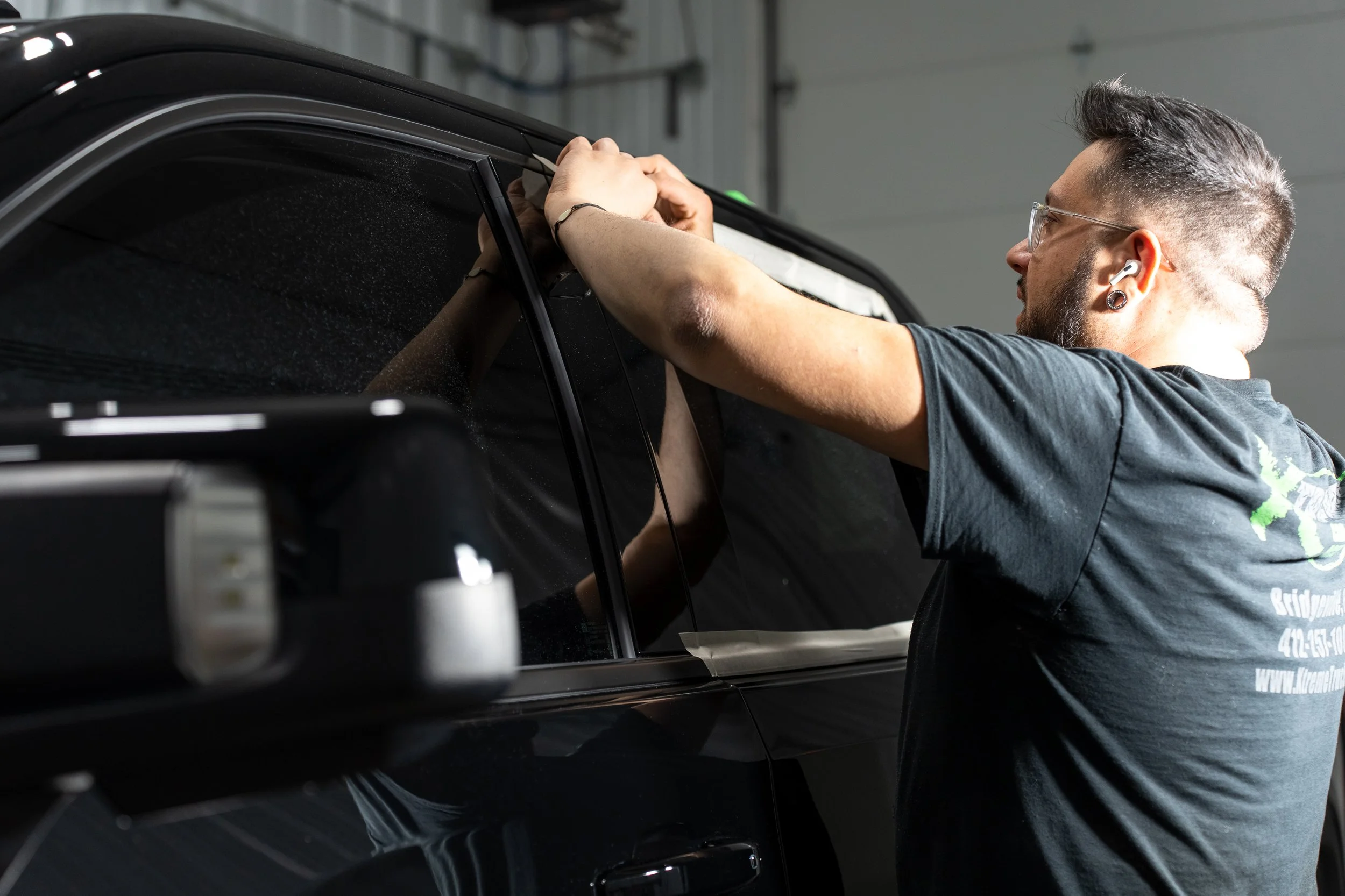 Technician machine polishing black truck during paint correction at Xtreme Car & Truck Accessories in Bridgeville, PA