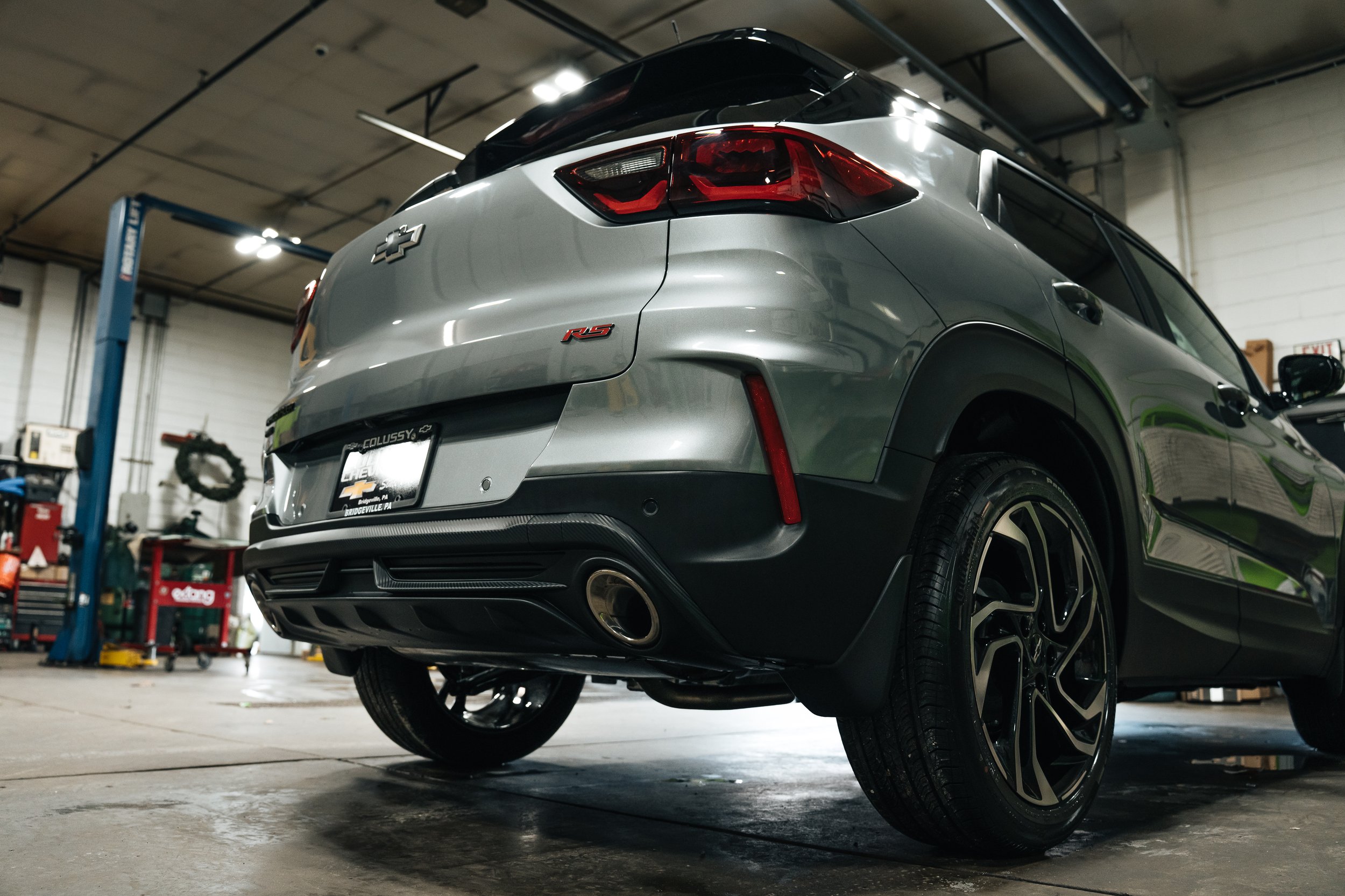 Professional automotive photography at Xtreme Car & Truck Accessories in Bridgeville, PA (Pittsburgh area) featuring a clean silver Chevrolet SUV from the rear with shop environment in the background