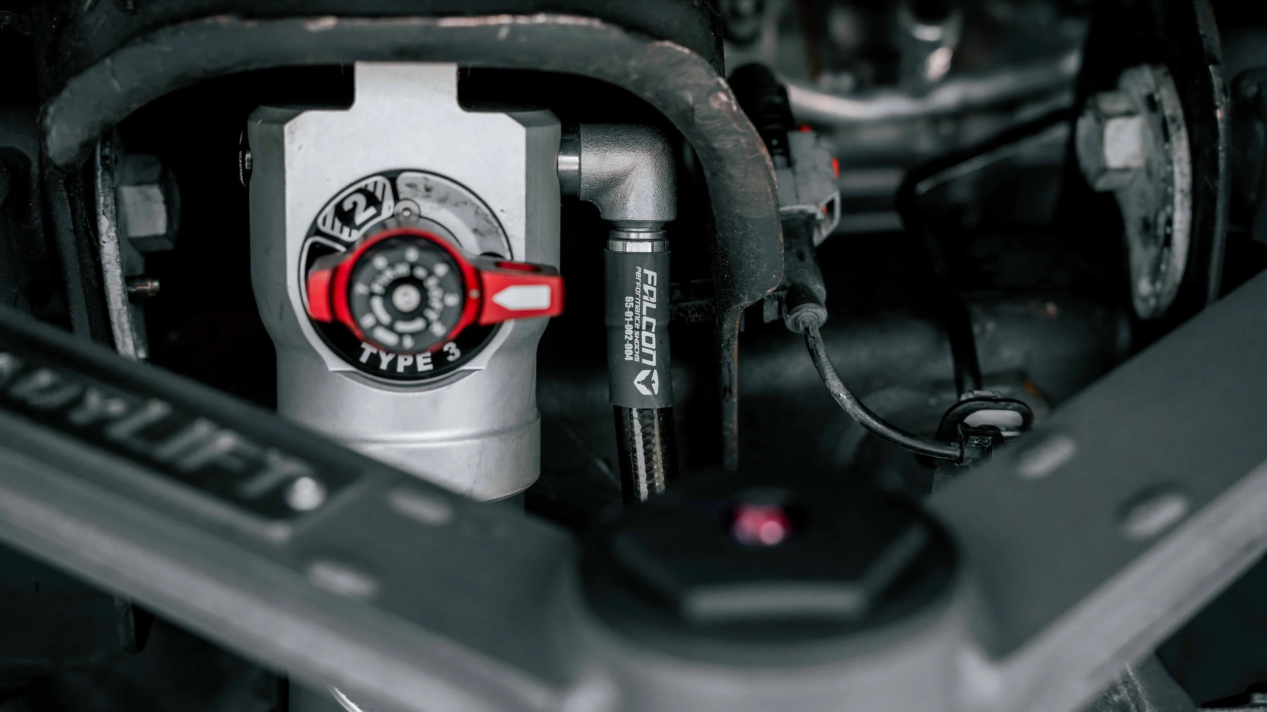 Detailed view of Falcon Type 3 shock and ReadyLIFT upper control arm on a GMC Sierra suspension lift.