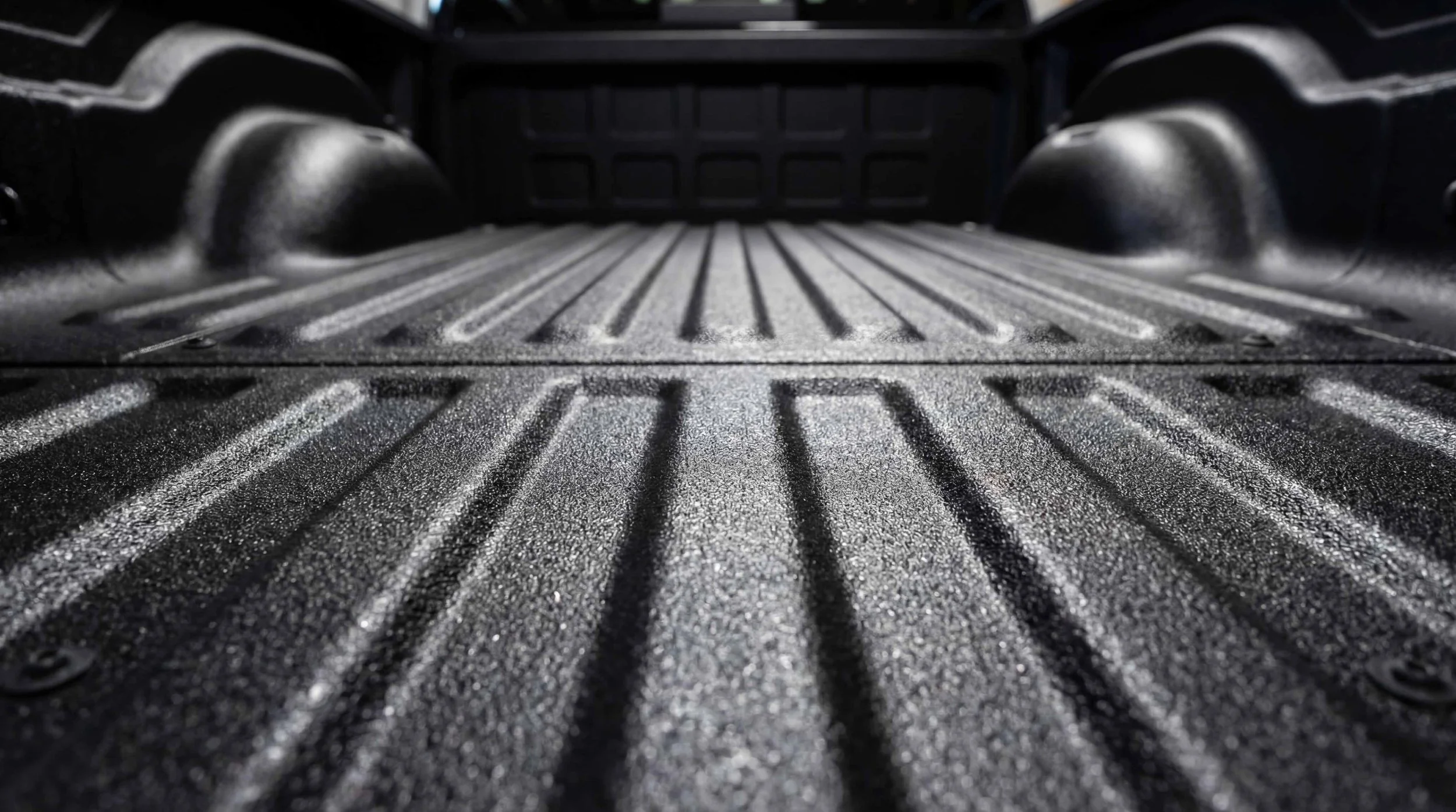 Finished black textured spray-in bed liner with a clean, durable surface in a pickup truck at Xtreme Car & Truck Accessories in Bridgeville, PA.