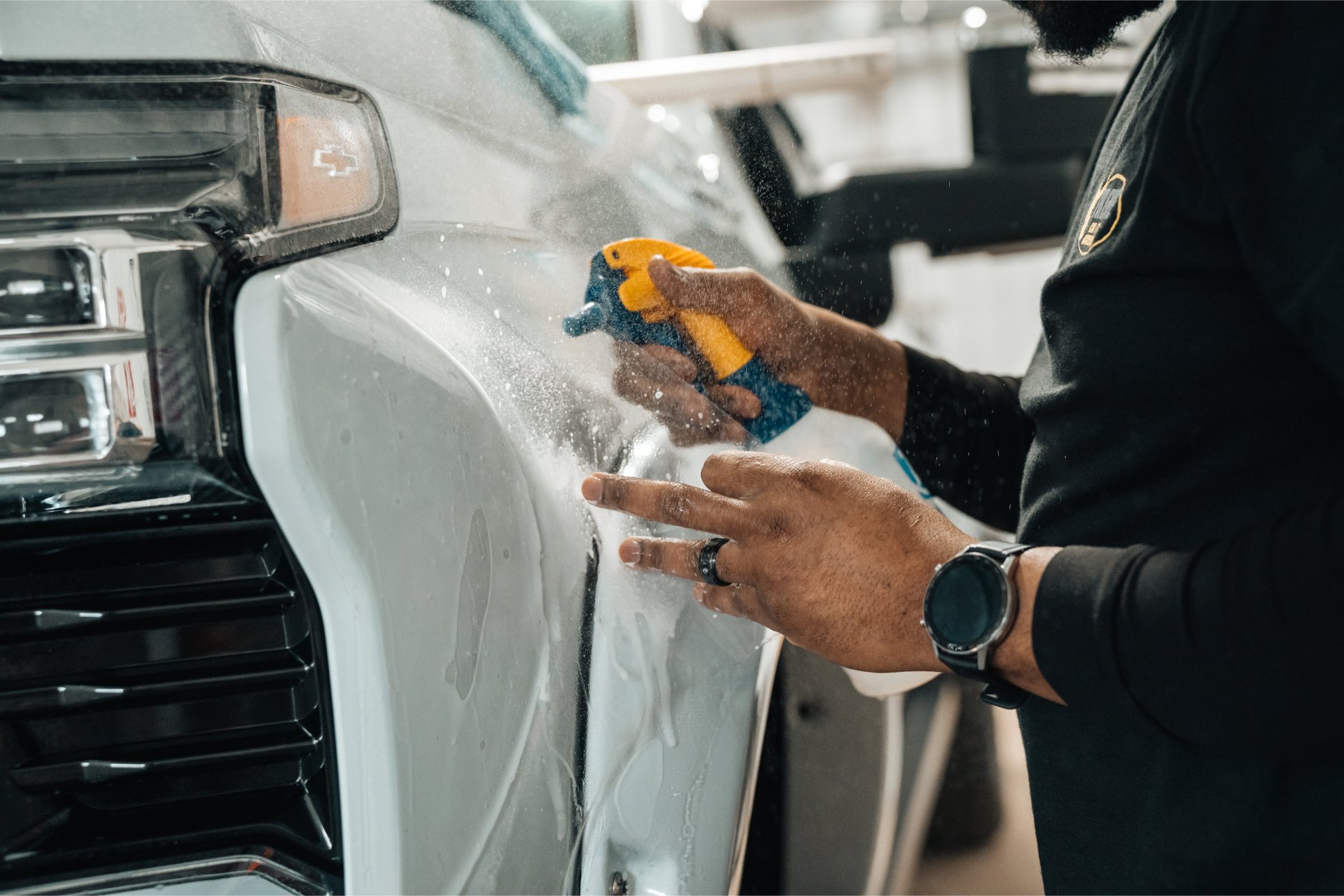 Technician installing XEL paint protection film (PPF) on the front fender of a truck at Xtreme Car & Truck Accessories.